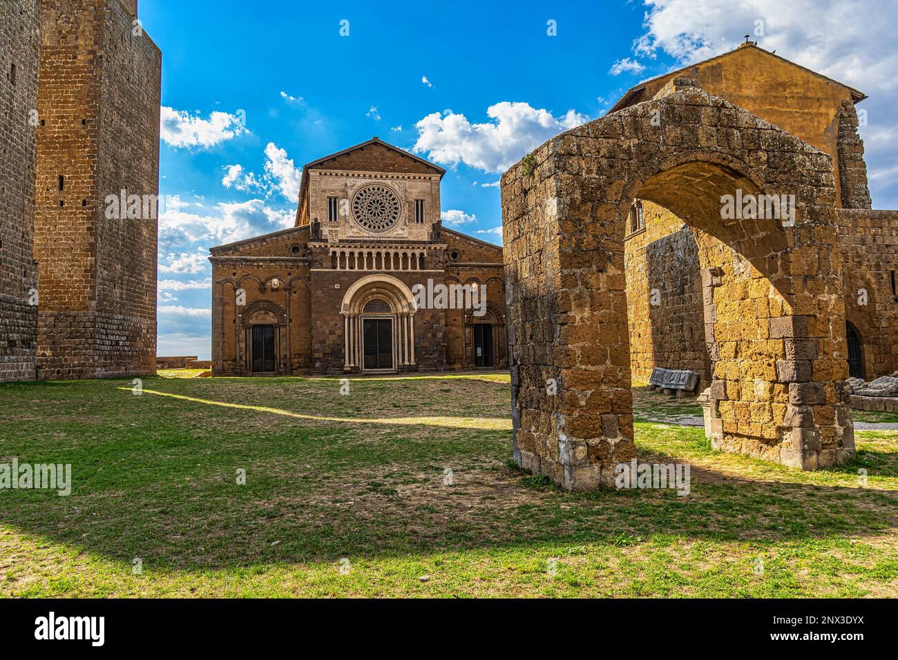 The Romanesque facade of the Basilica of San Pietro in Tuscania with the three defense towers and the ancient entrance arch. Tuscania, Lazio Stock Photo