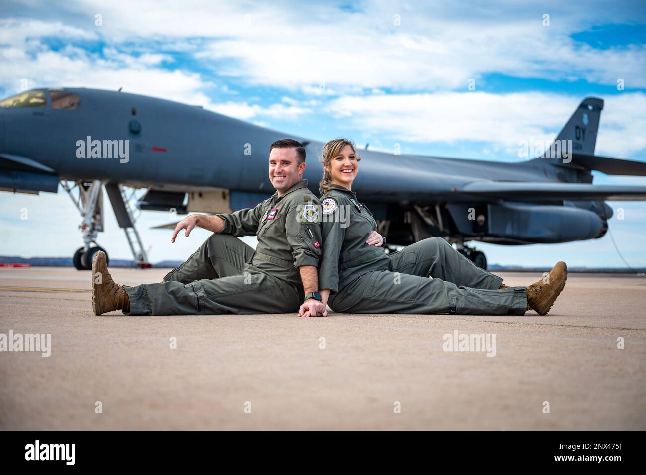 U.S. Air Force Maj. Lauren Olme, 77th Weapons Squadron assistant director of operations, and her husband, Maj. Mark Olme, 7th Operations Support Squadron bomb wing weapons officer, pose for a photo next to a B-1B Lancer at Dyess Air Force Base, Texas, Feb. 20, 2023. Lauren, who is currently pregnant, can continue flying after recently getting approved under the Air Force’s new guidance which allows female aircrew members to voluntarily request to fly during pregnancy. No waiver is required to fly in the second trimester with an uncomplicated pregnancy in a non-ejection seat aircraft if all fli Stock Photo