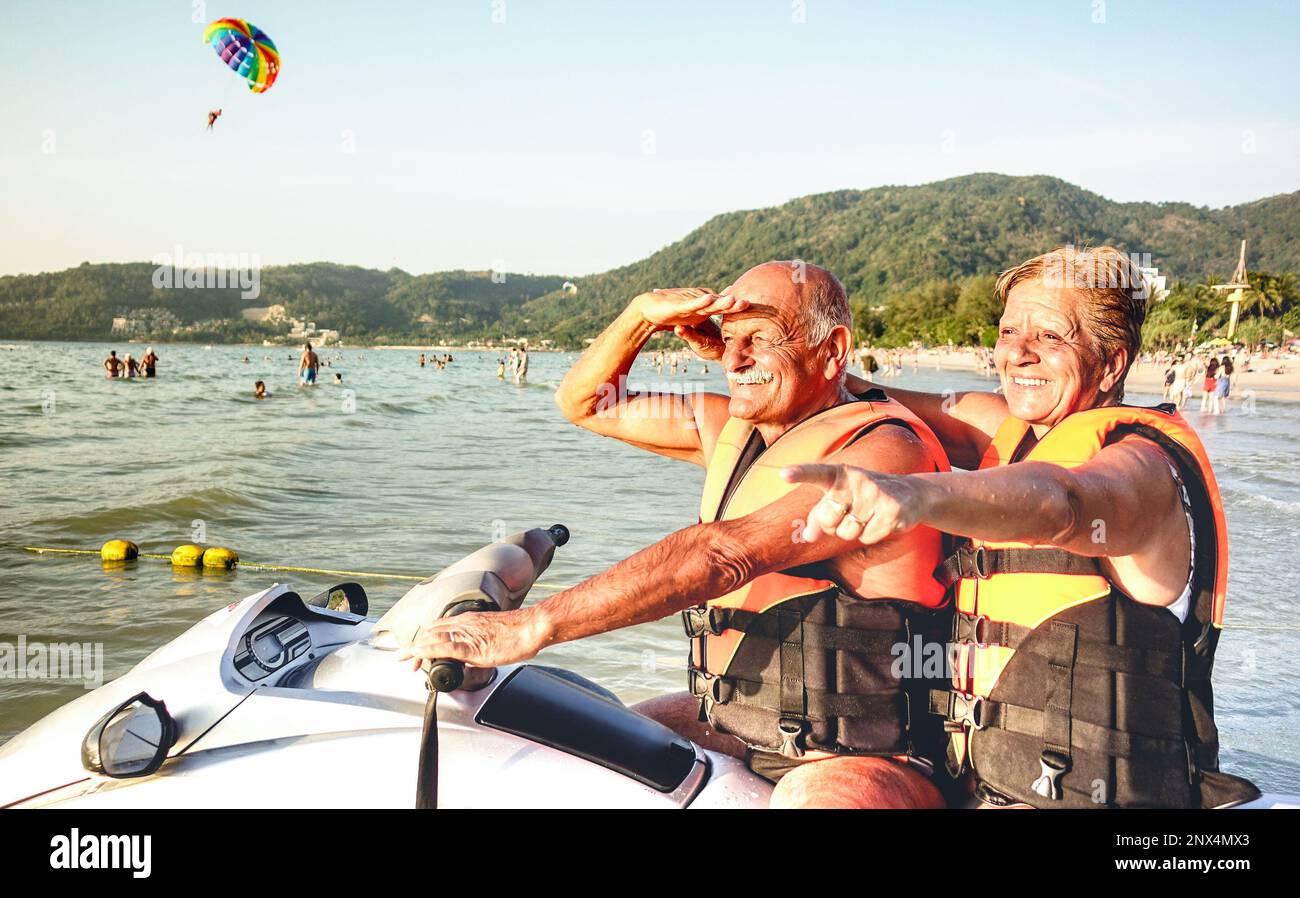 Senior happy couple having fun on jet ski at beach island hopping tour