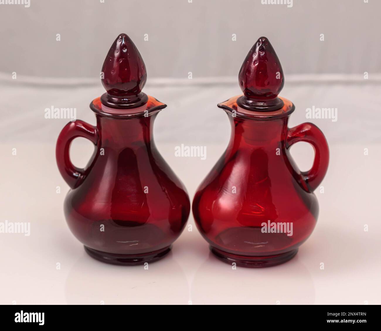 two small red glass jugs with stoppers Stock Photo