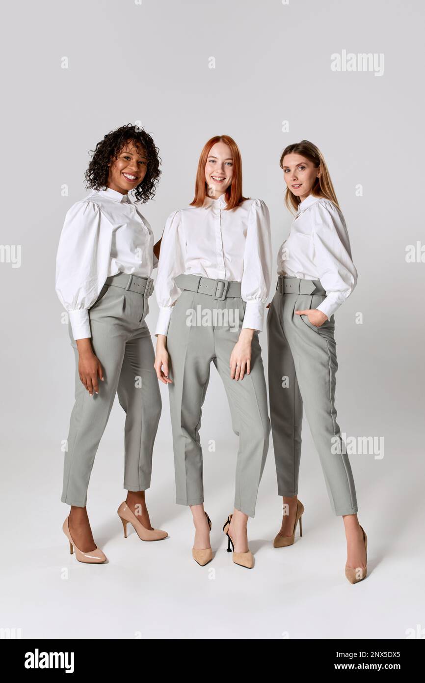 Three fashionable stylish young women in office style clothes posing over light background. Concept of beauty fashion business Stock Photo Alamy