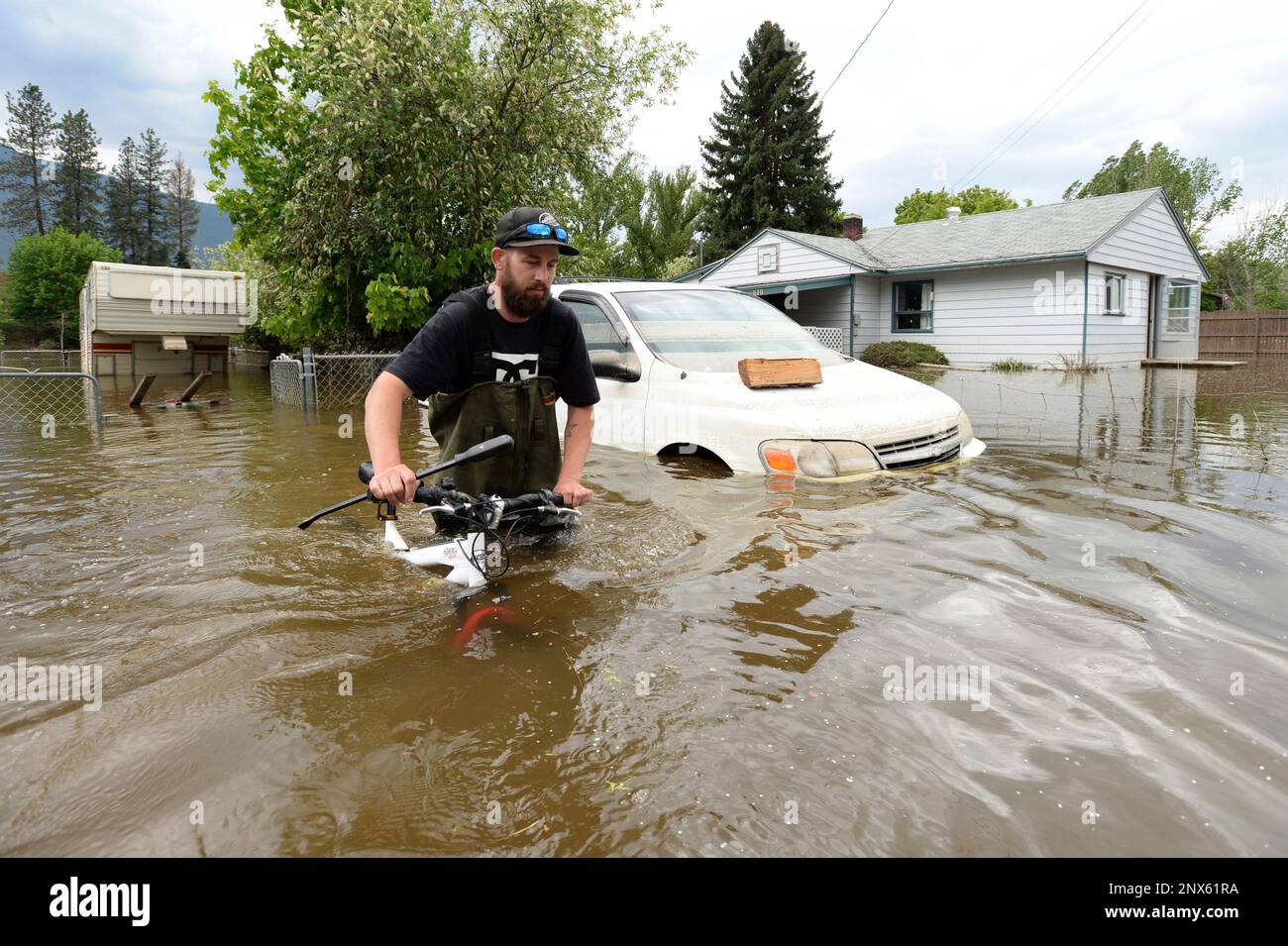 Resident Kyle Piper carries his bike from his house through the ...