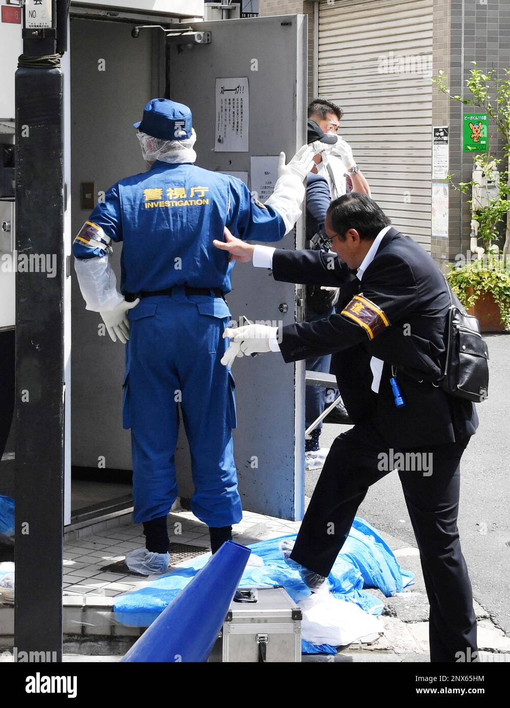 The Tokyo Metropolitan Police Department officers inspect the scene of ...