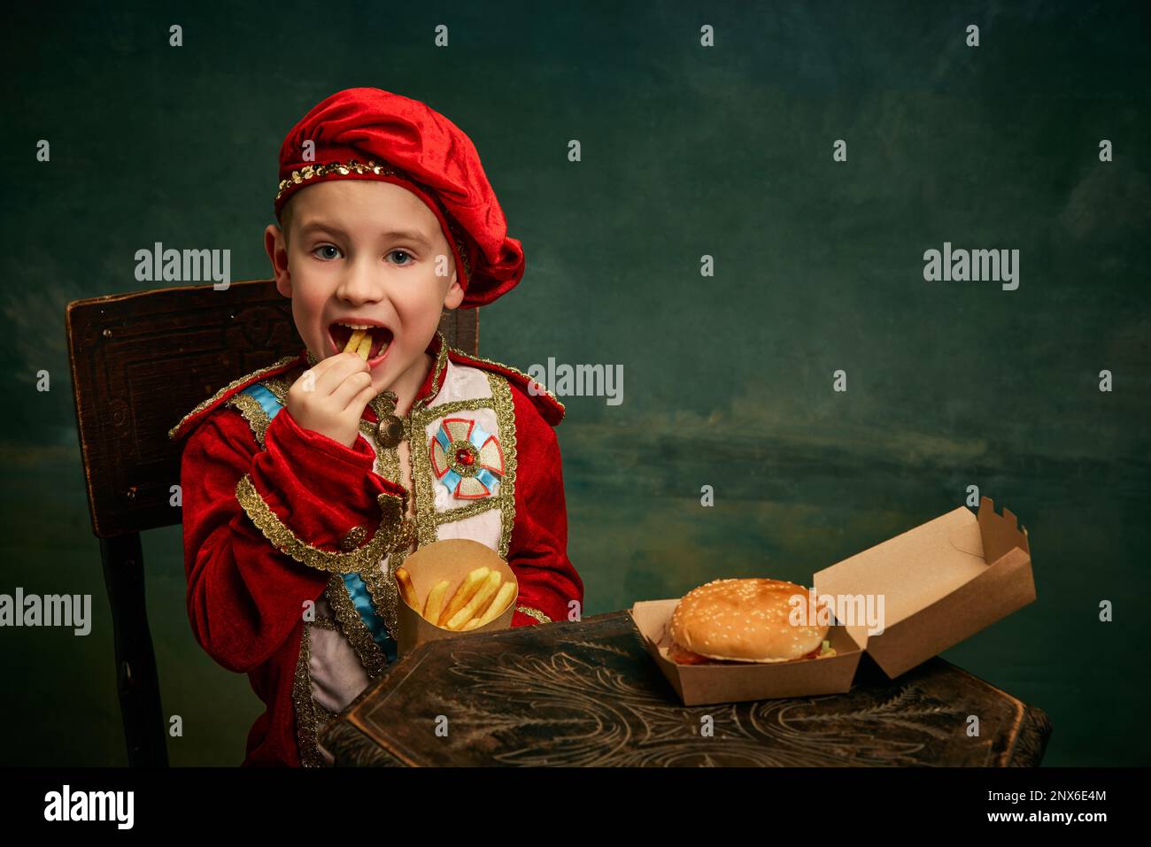 Happy cheerful little boy wearing costume of medieval page boy and