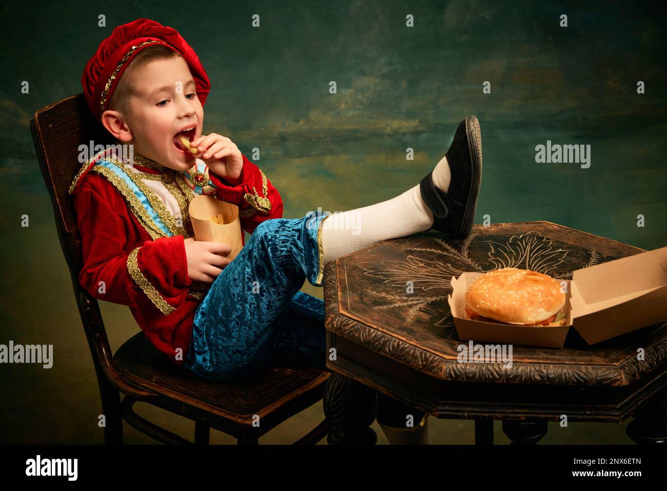 Happy cheerful little boy wearing costume of medieval page boy and