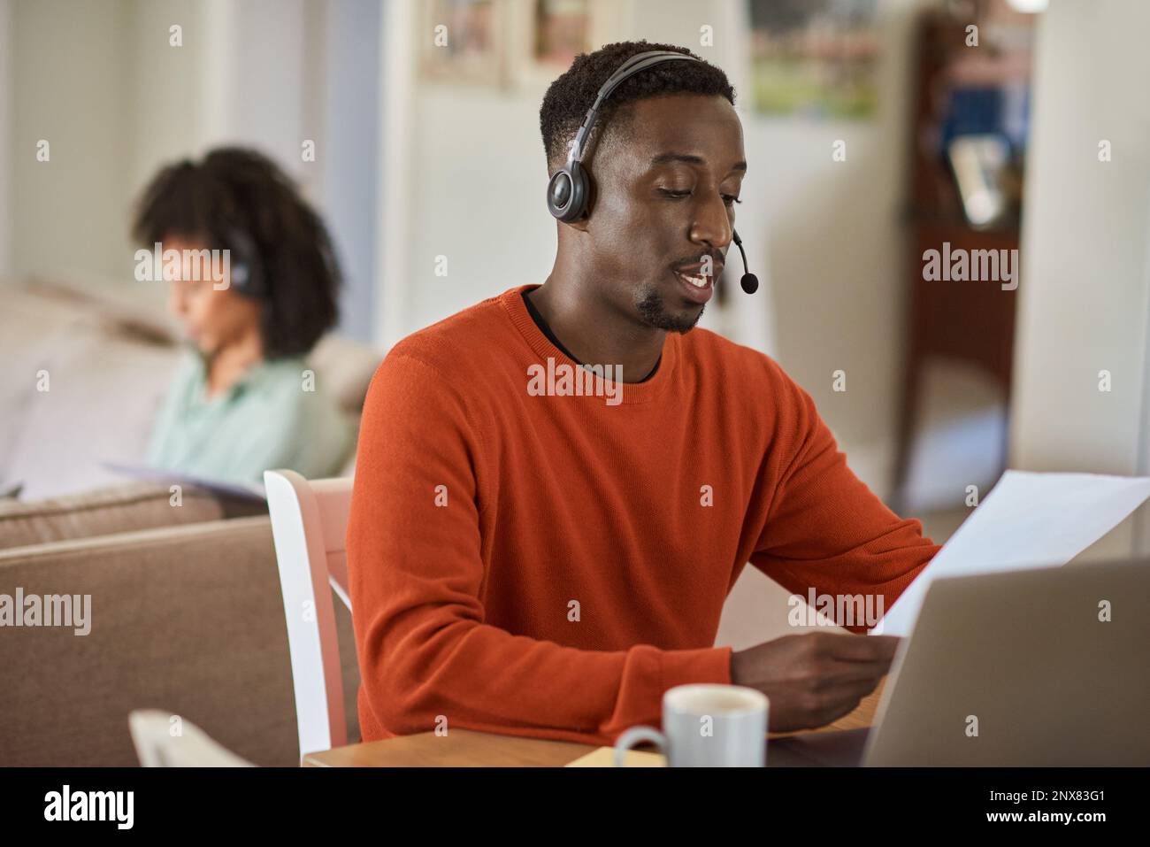 Young African man on a call while working remotely from home Stock Photo