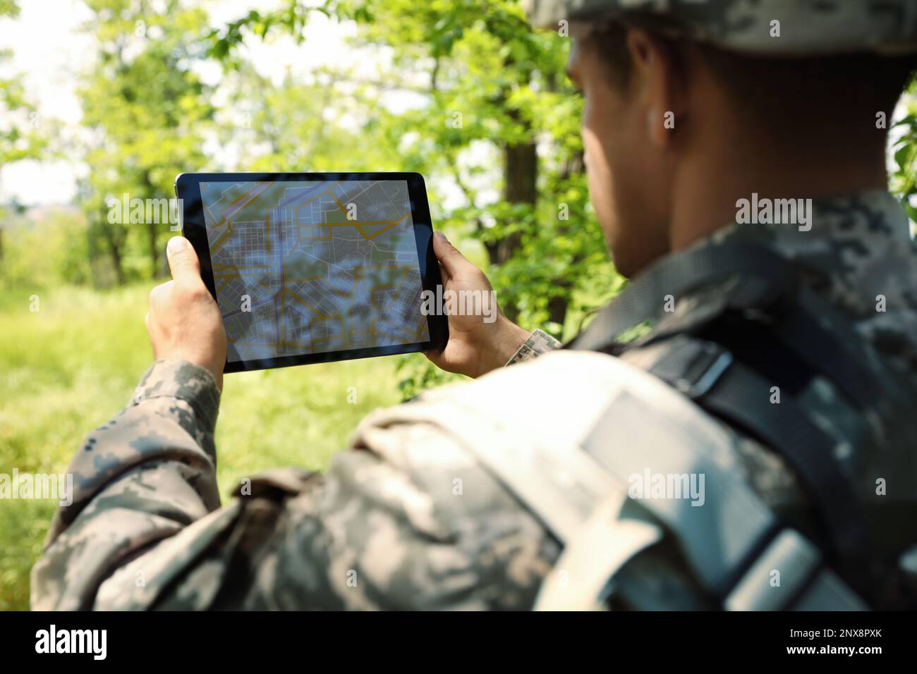 Soldier using tablet in forest. Modern technology Stock Photo