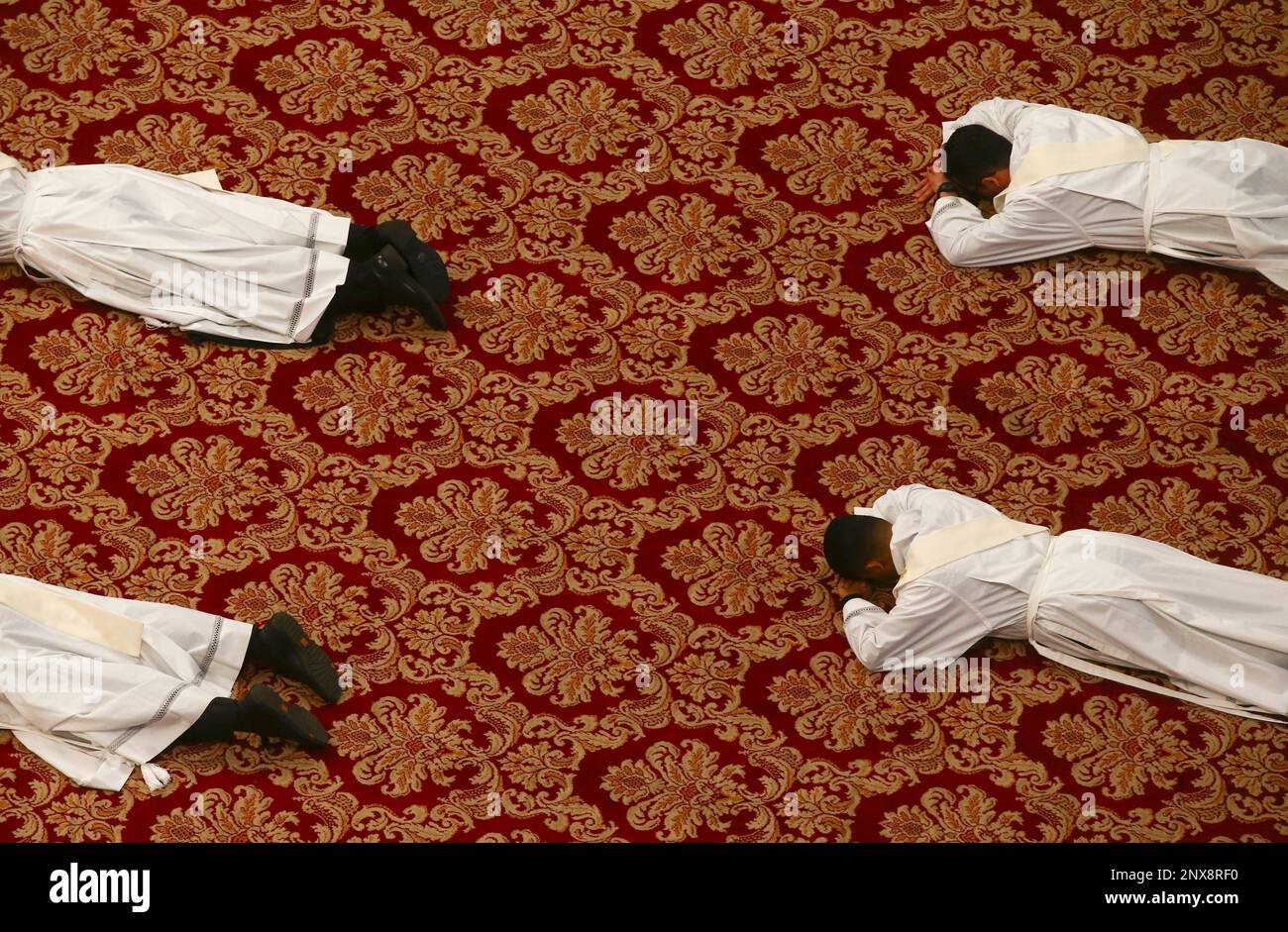 New priests lie face down on the floor during an ordination ceremony presided over by Pope