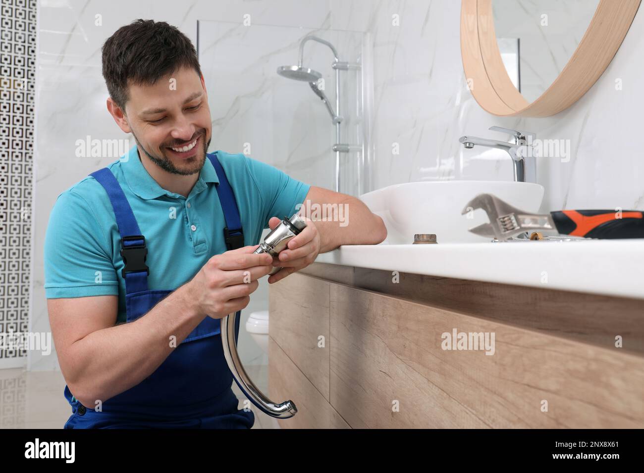 Professional plumber fixing water tap in bathroom Stock Photo Alamy