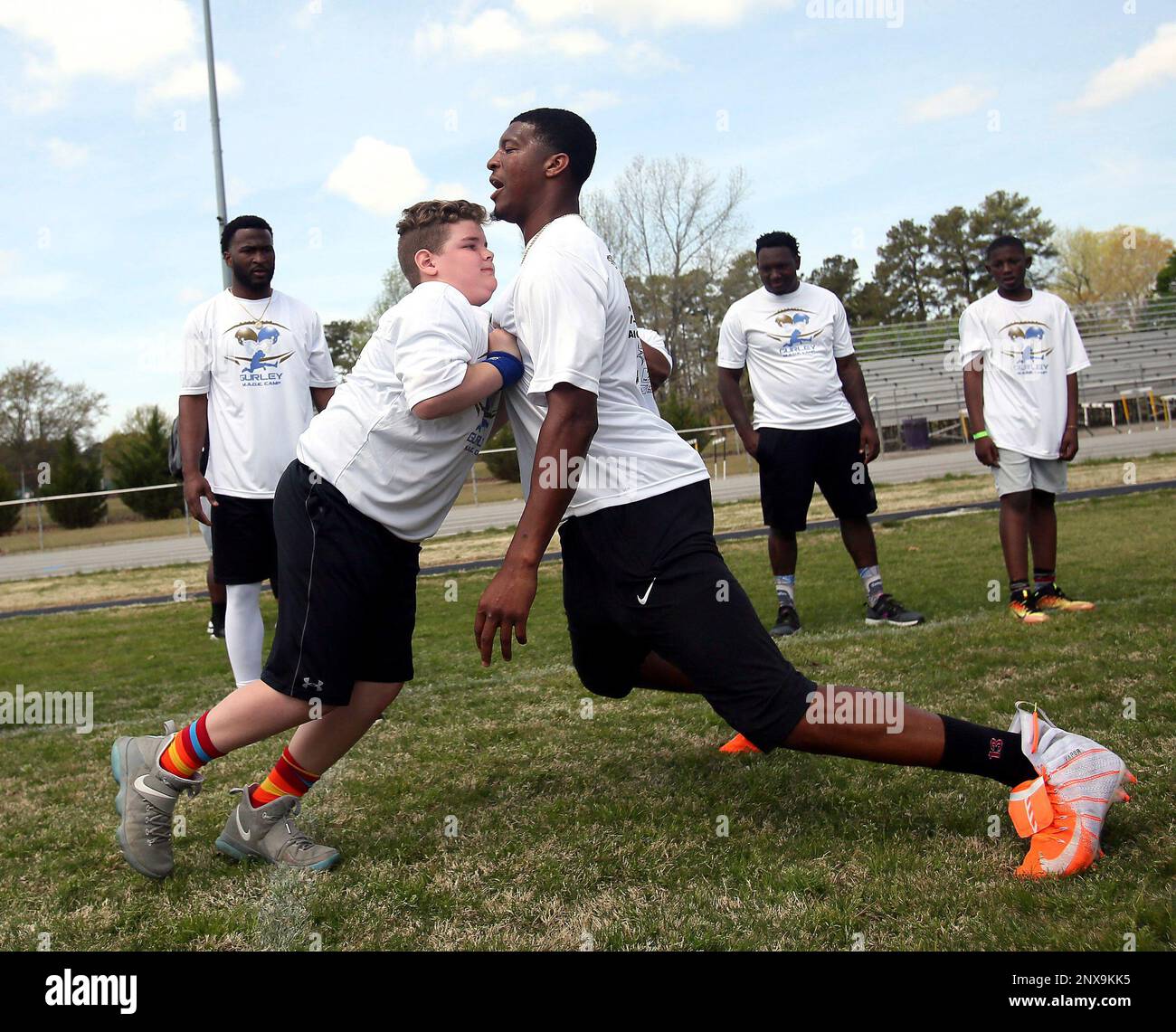 Tampa Bay Buccaneers quarterback Jameis Winston, center, talks to Avery  Garner, 11, as he coaches him during Todd Gurley's youth football camp at  Tarboro High School in Tarboro, N.C.. (Alan Campbell/Rocky Mount