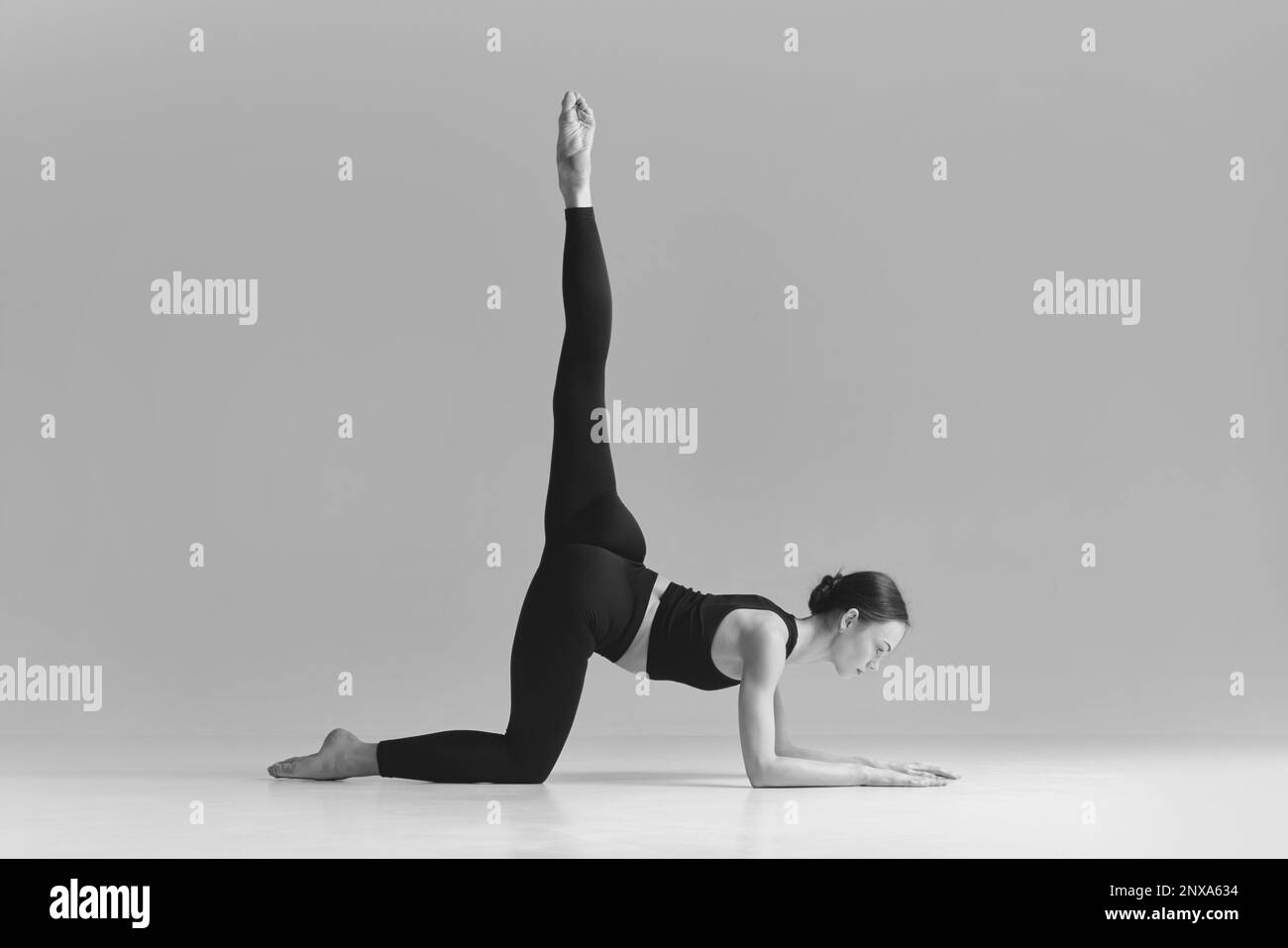 Black and white photography. Young girl doing stretching exercise