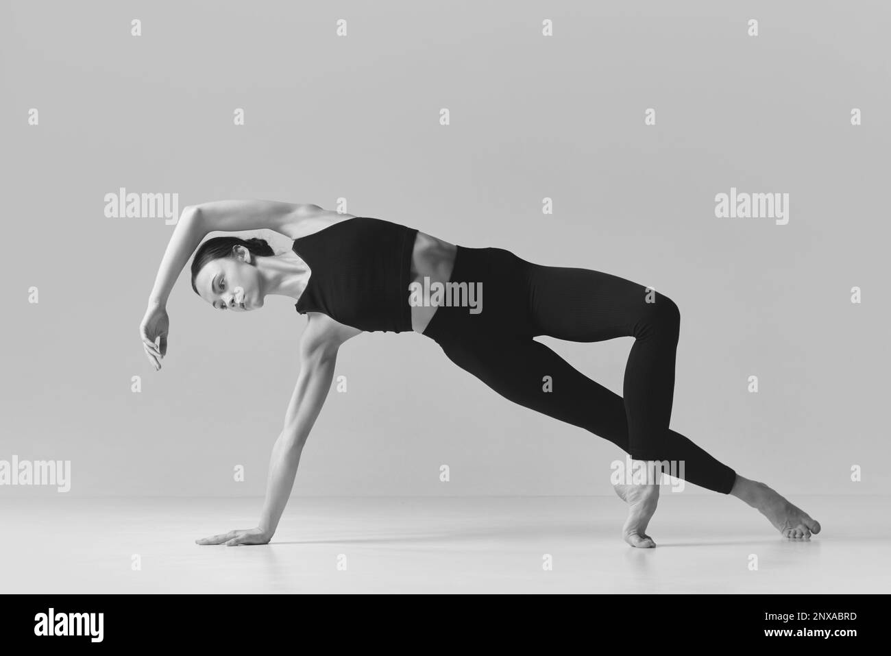 Grace. Black and white photography. Young slim, fit girl training