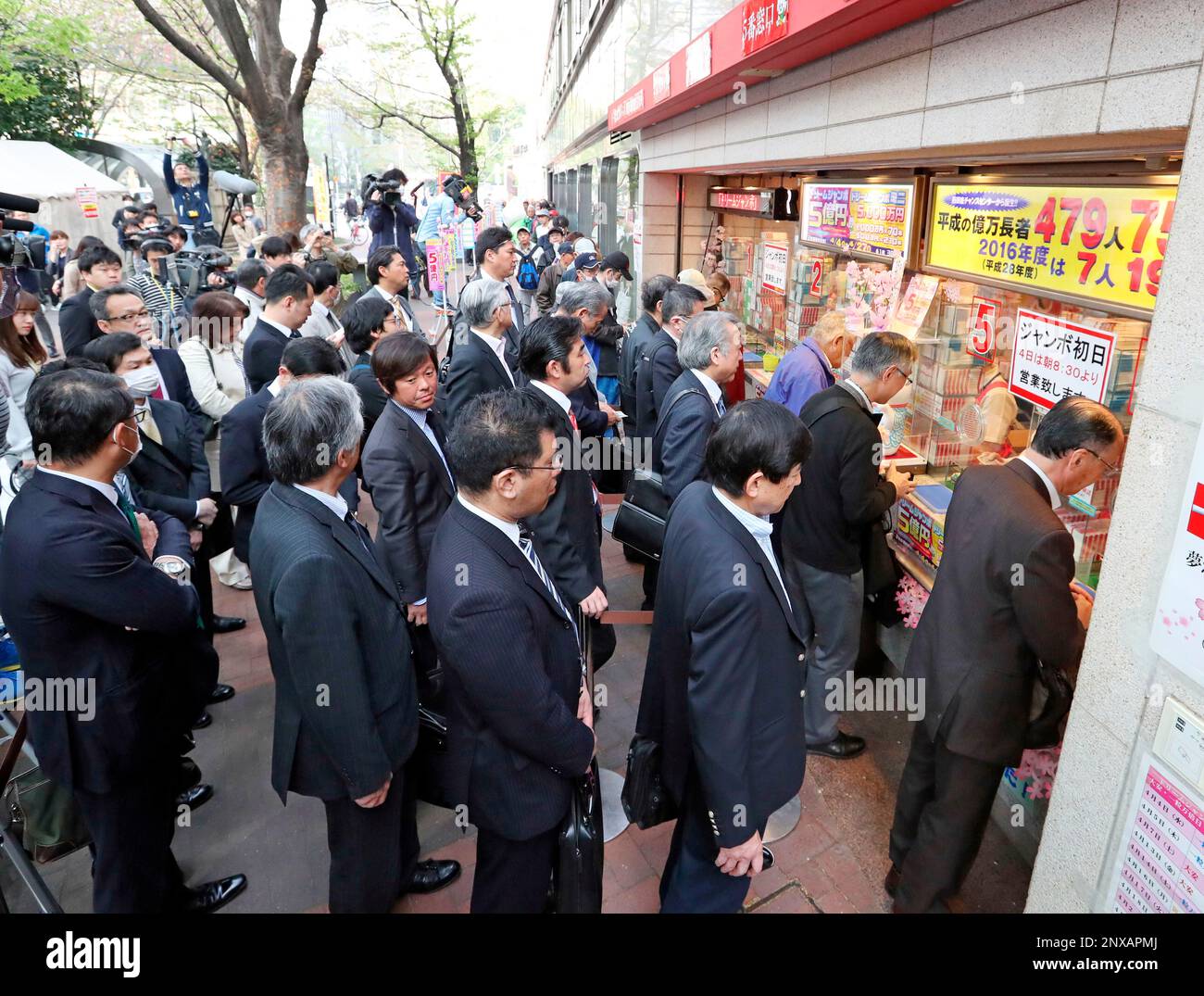 People form a long queue along a booth to purchase the 
