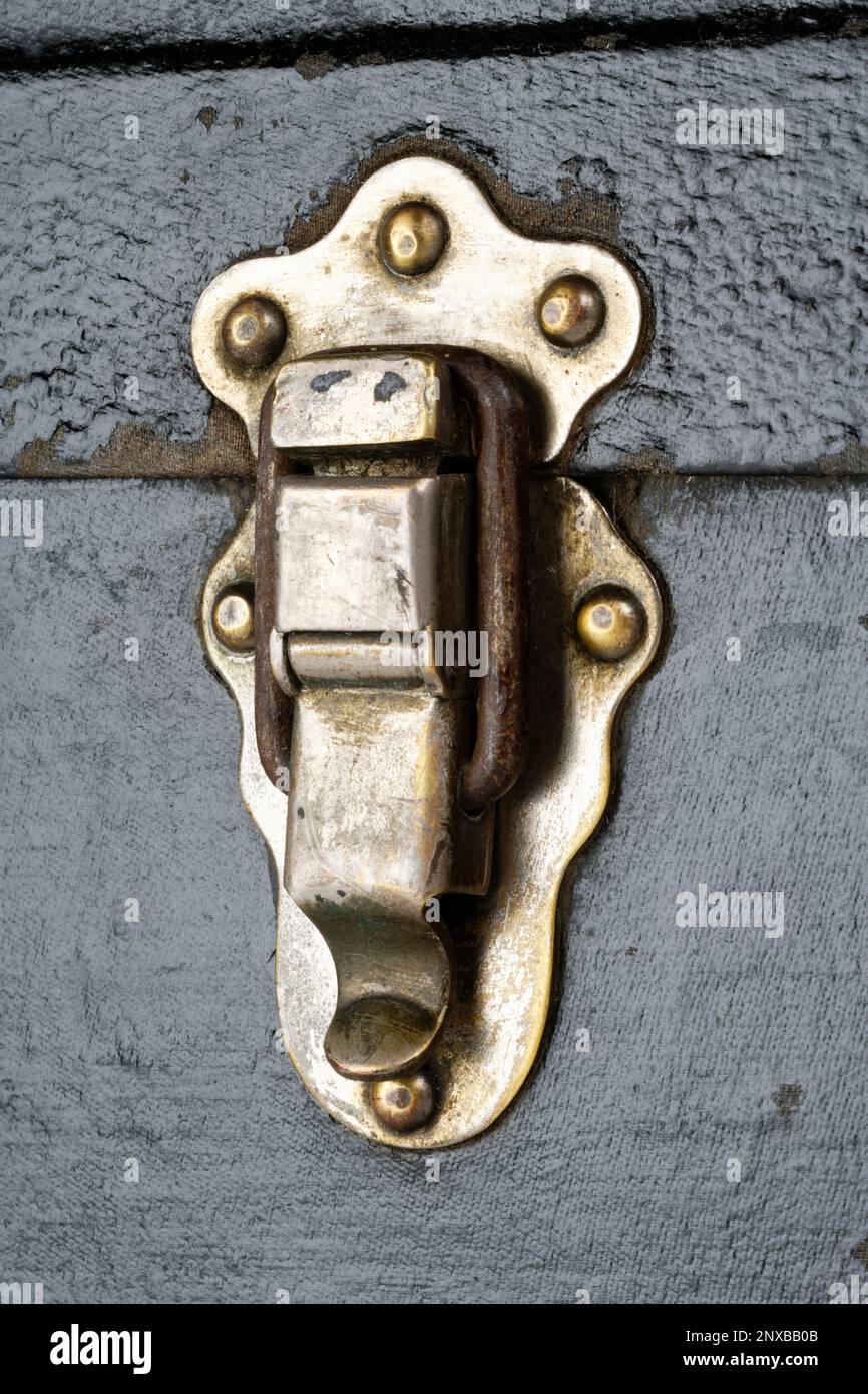 Clasp or lock of an old fashioned wooden trunk. A black trunk with metal reinforced corners and leather trimmed edges and strong metal lock. Stock Photo
