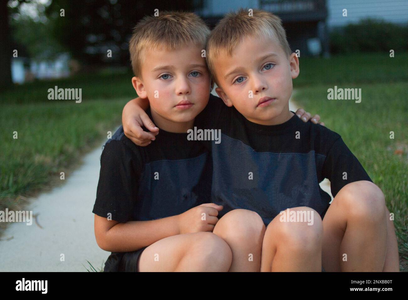 Two boys with arms around each other hi-res stock photography and ...