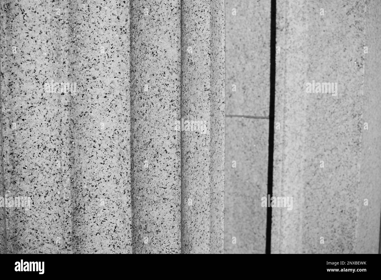 A closeup view of a fluted column carved in natural stone in a black