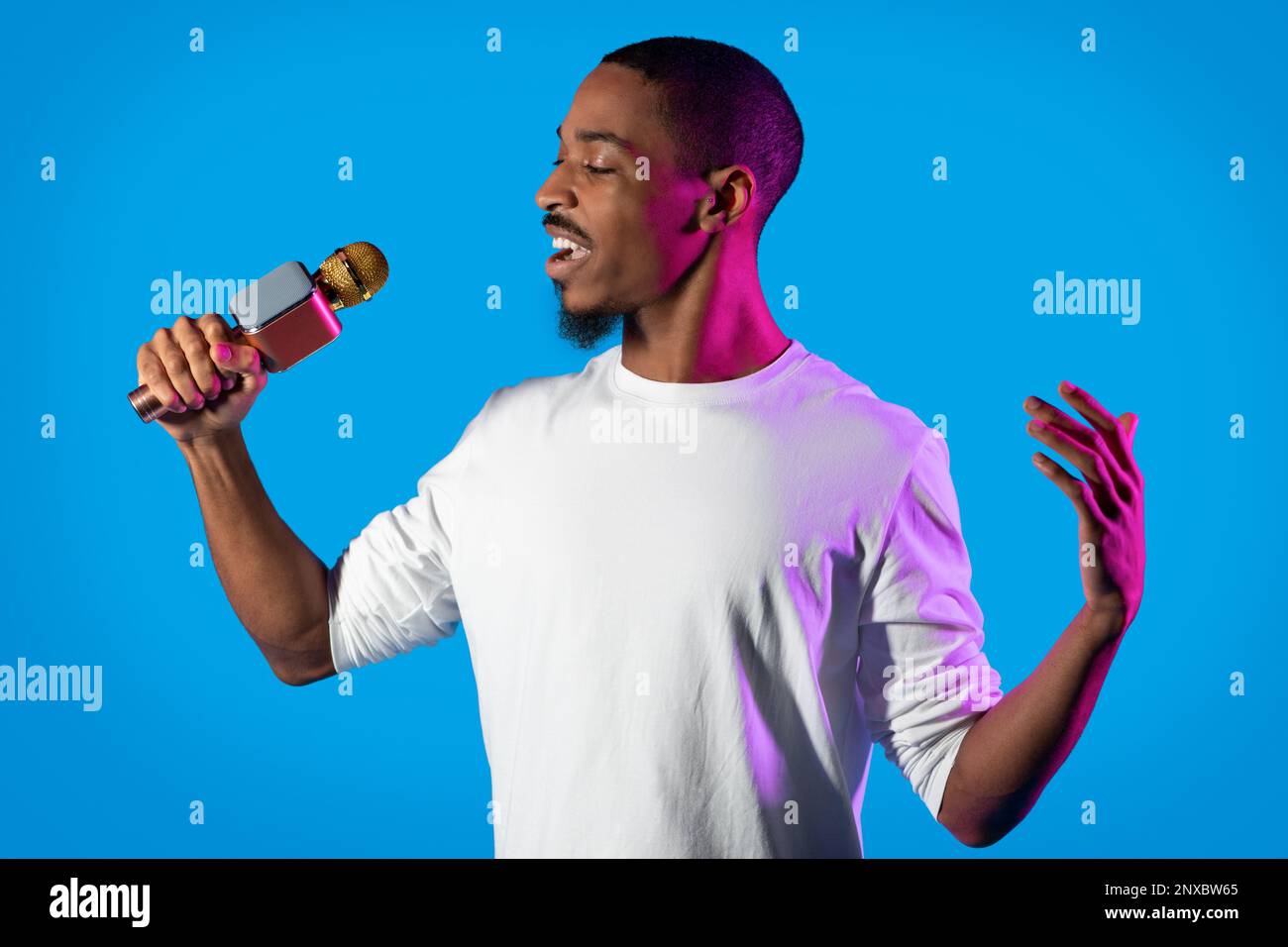 Emotional african american guy performing singing on blue Stock Photo