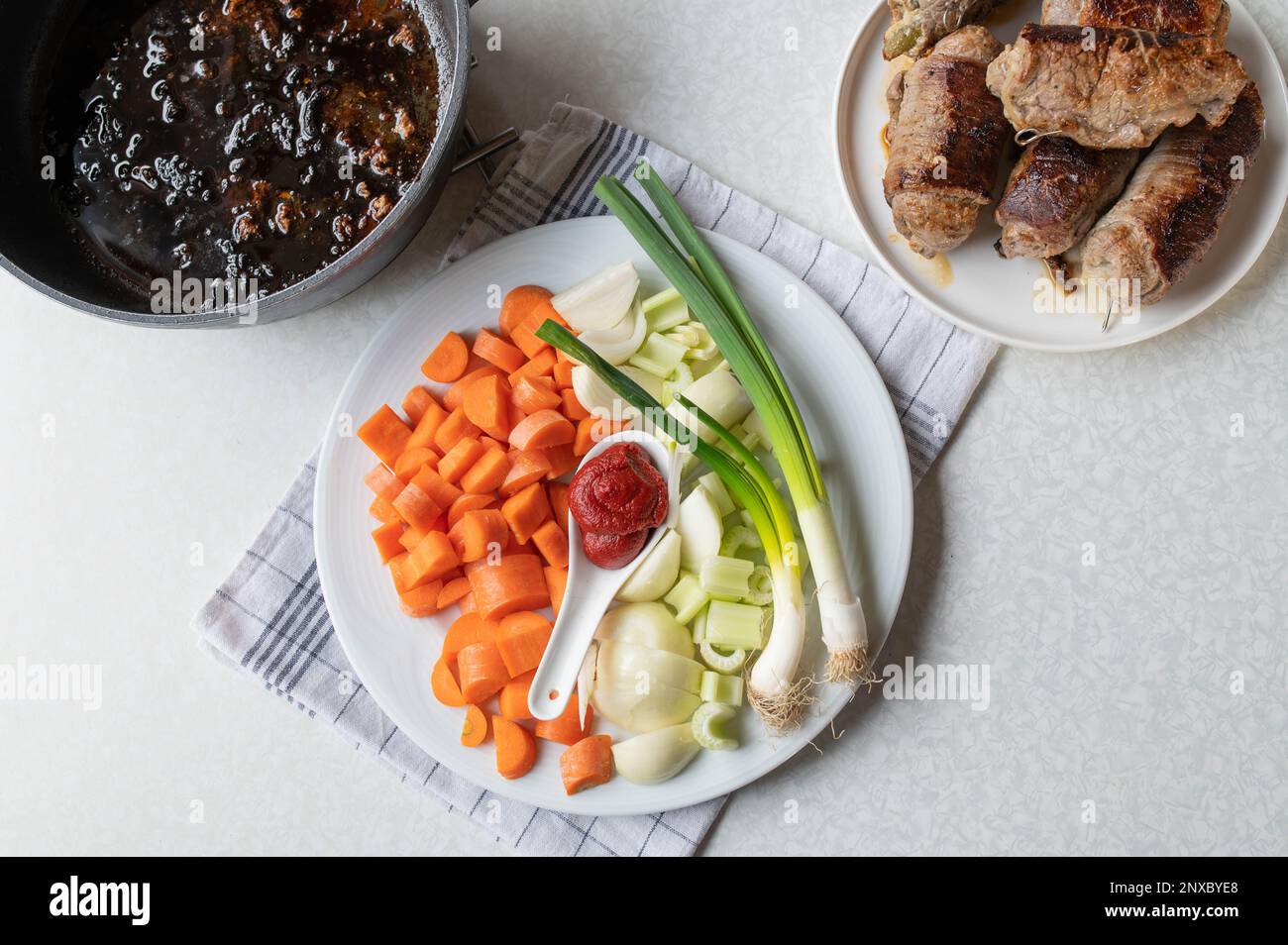 Beef roulades cooking, making prepartion. Mirepoix or chopped root vegetables for making gravy. Part of a series Stock Photo