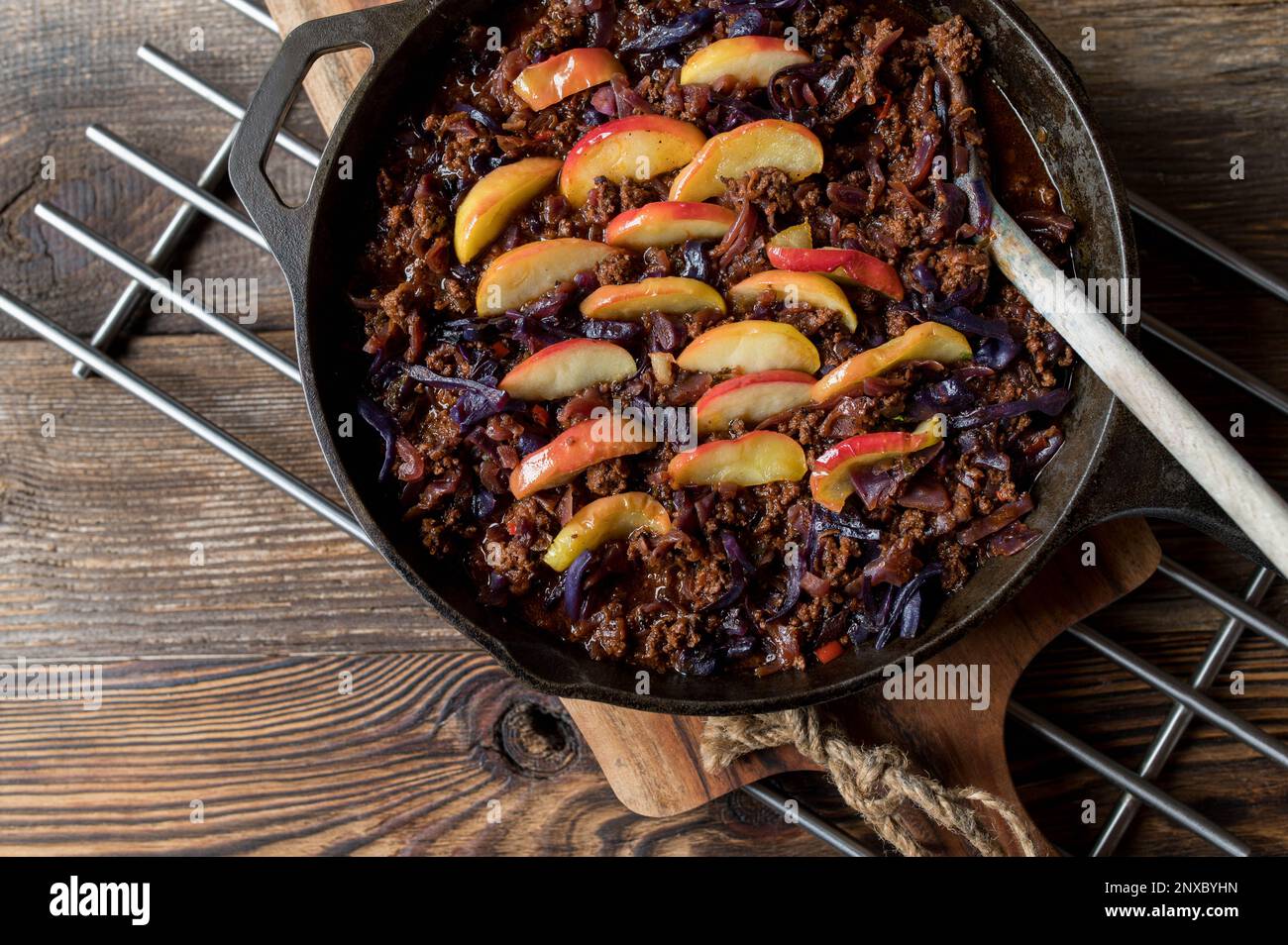 Ground beef pan with red cabbage and cooked apple topping in a cast