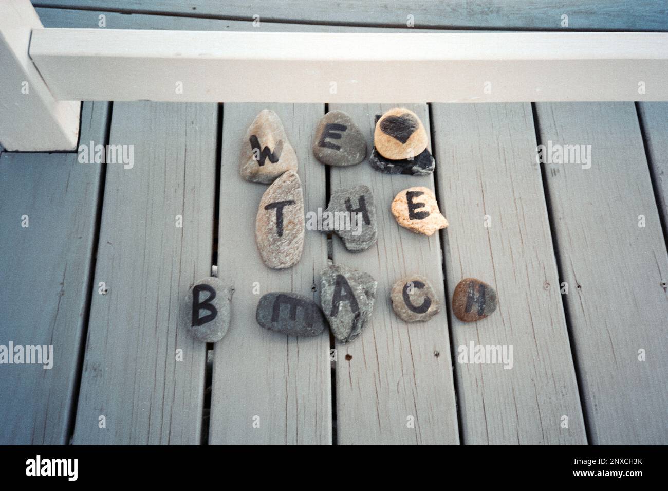 Painted beach stones spell out We Love The Beach on the deck of an off-season rental at North Hampton beach, New Hampshire. The image was captured on Stock Photo