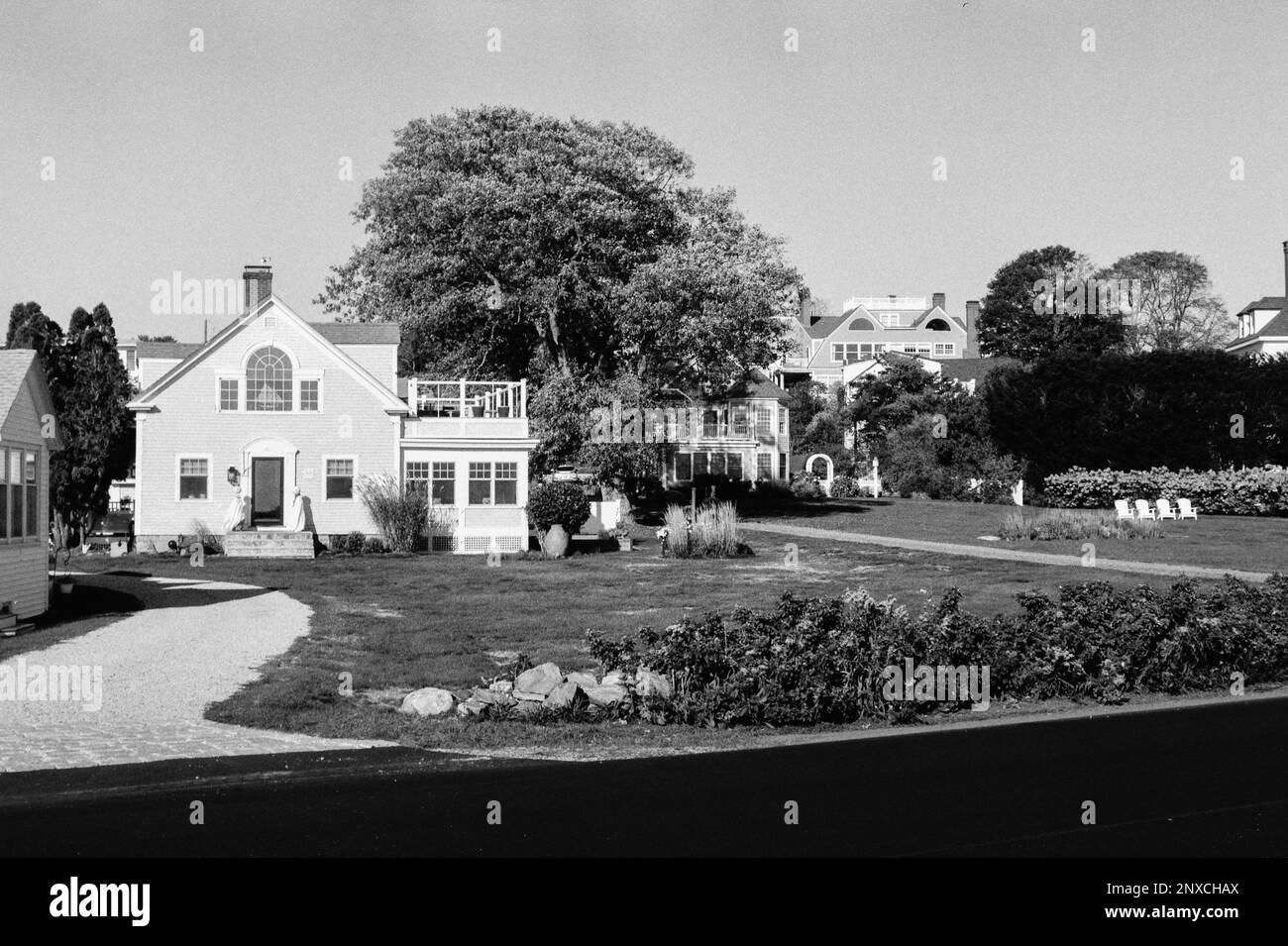 A bright beach home with stone pillars marking the driveway with a