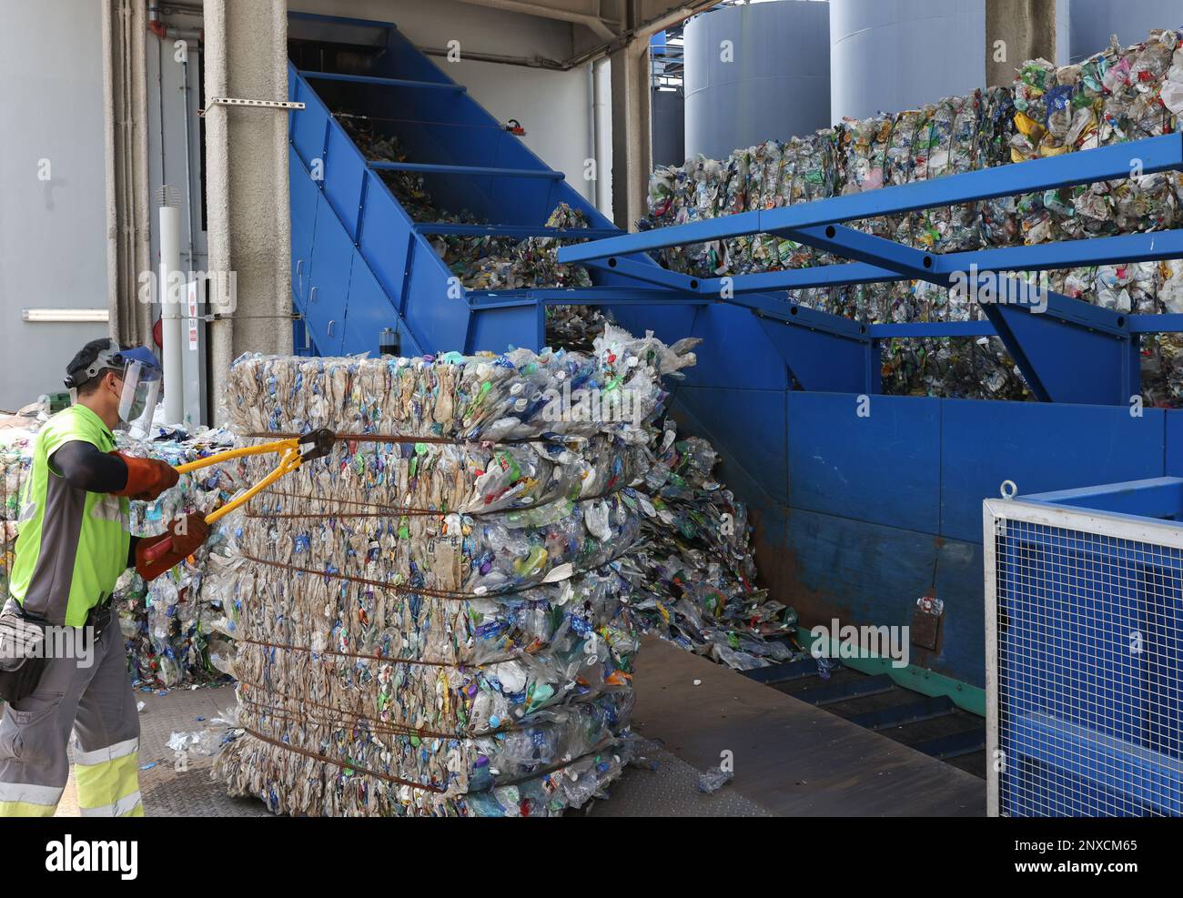 A worker transfer recycling plastic bottles to a bale breaker at New