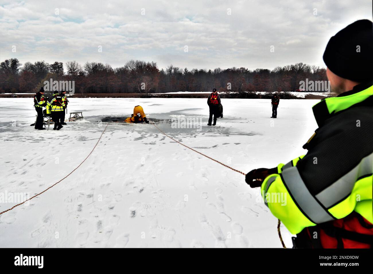 Firefighters wearing cold-water immersion protective suits hold surface ...