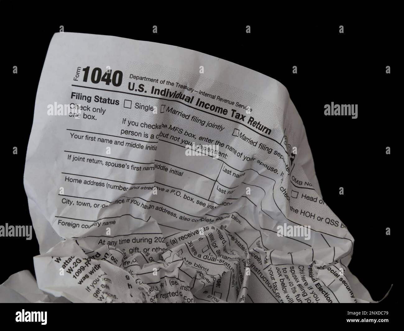 A wrinkled IRS 1040 tax form in the USA is shown in a closeup view, symbolizing the concept of frustration with the tax preparation process. Stock Photo
