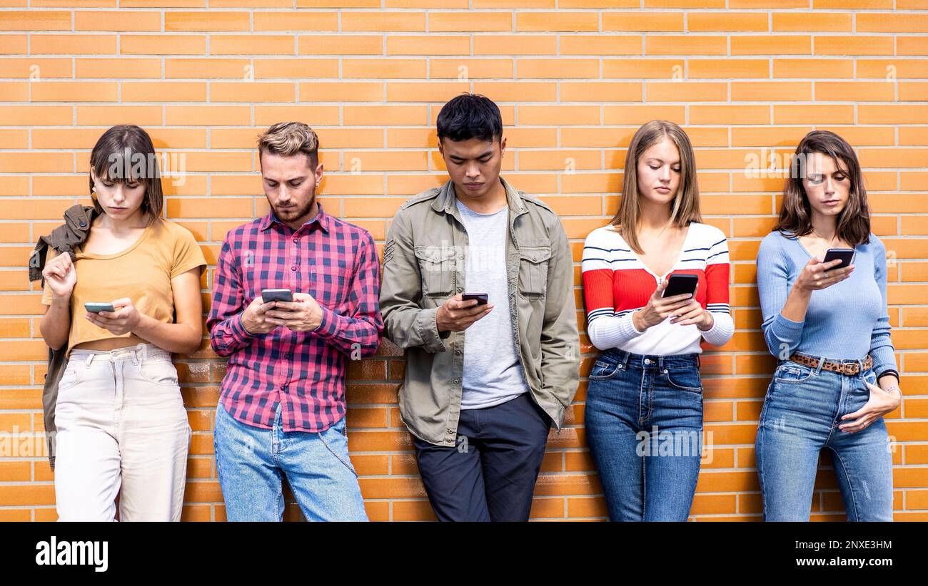 Multicultural people group using smartphone at university college backyard - Gen z apathetic friends addicted by mobile smartphone - Technology concep Stock Photo