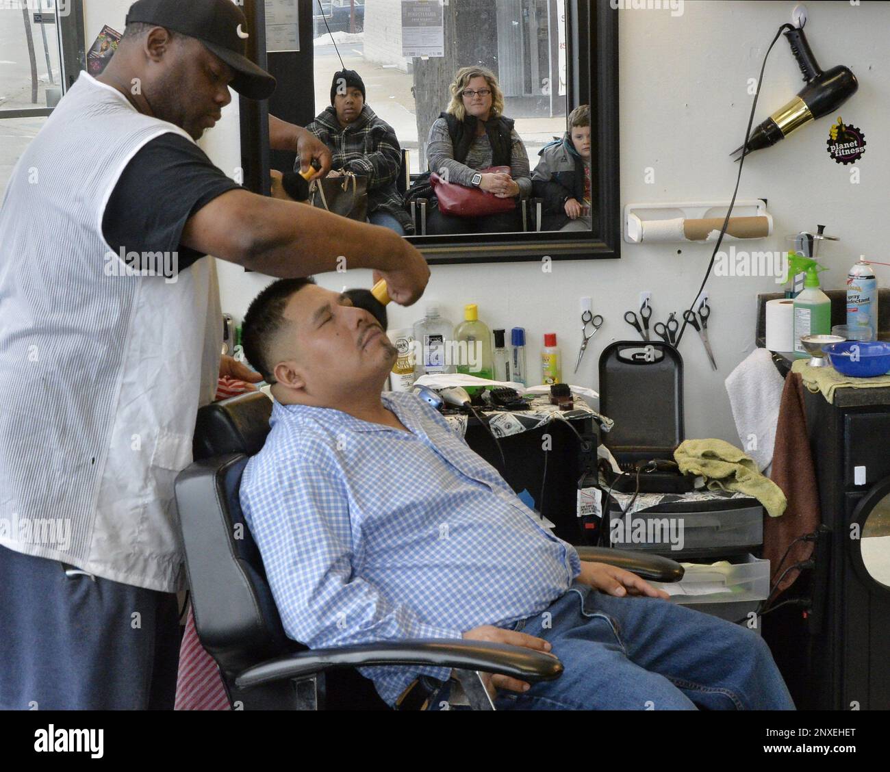 In this Feb. 17, 2018 photo, Boss Cuts head barber Bruce Anderson, left