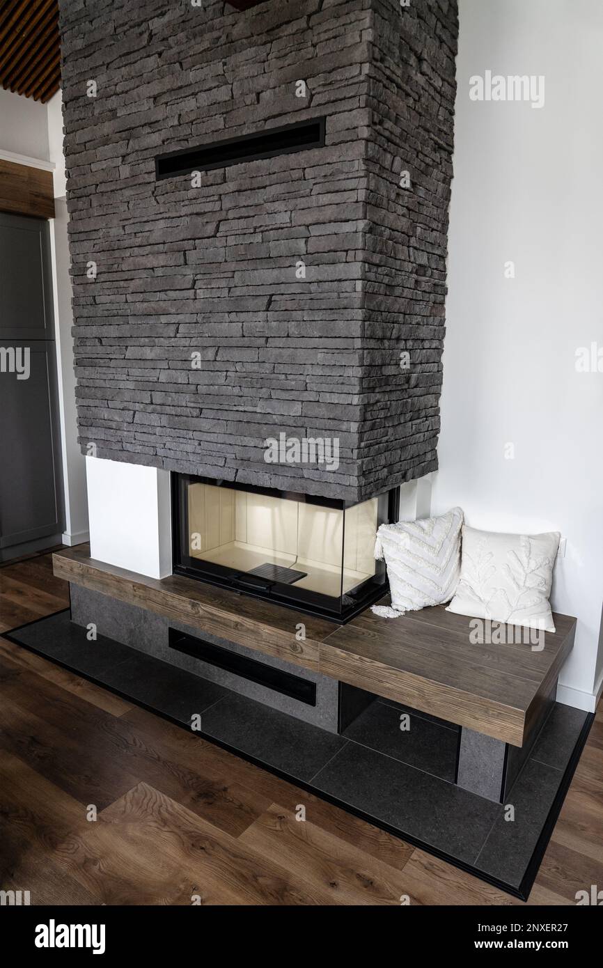 modern fireplace with stone texture and corner window natural style Stock Photo