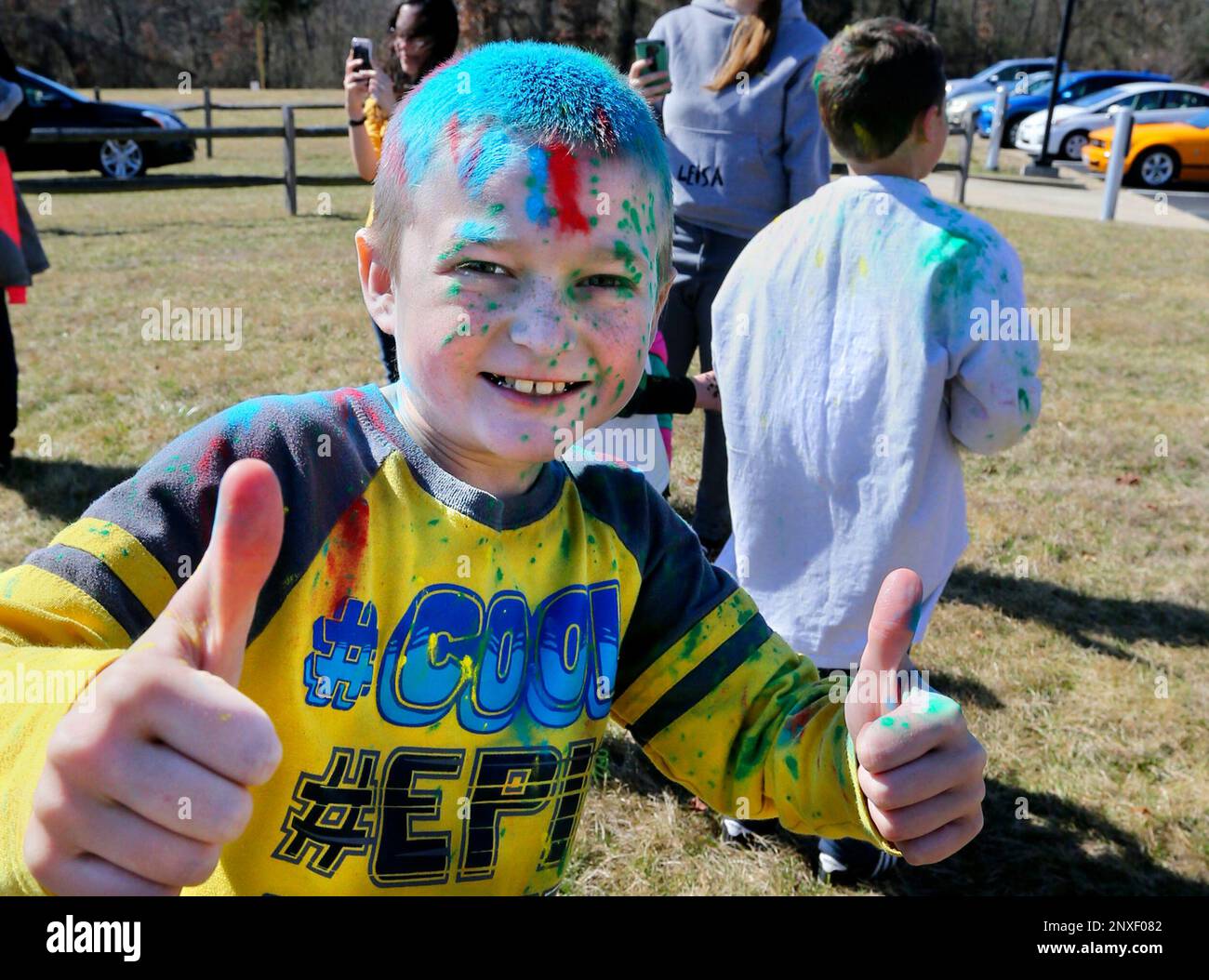 Dennis Hart, 8, leaves the Holi Festival of Colors doused in various