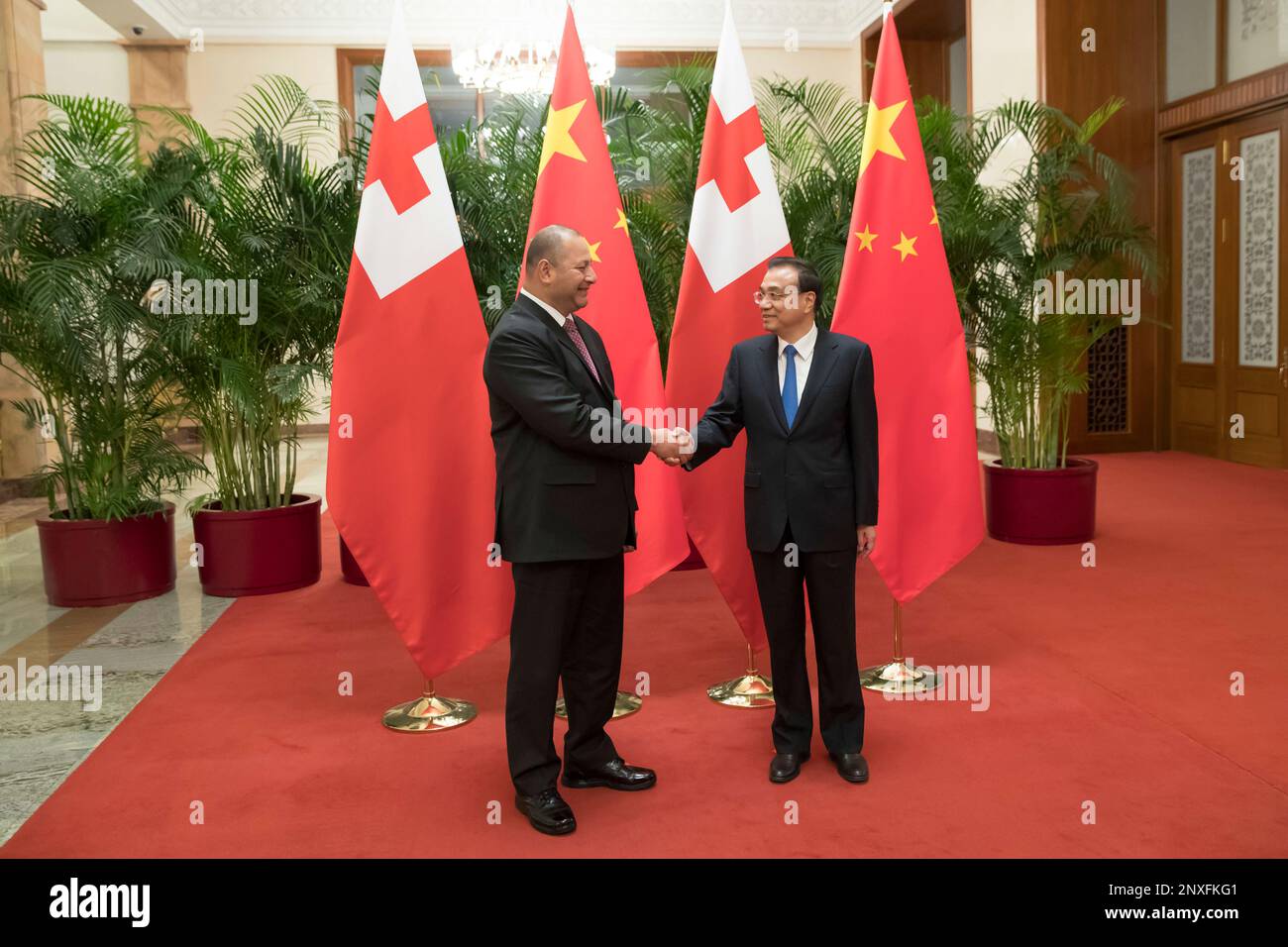 King Tupou VI of Tonga, left, shakes hands with Chinese Premier Li