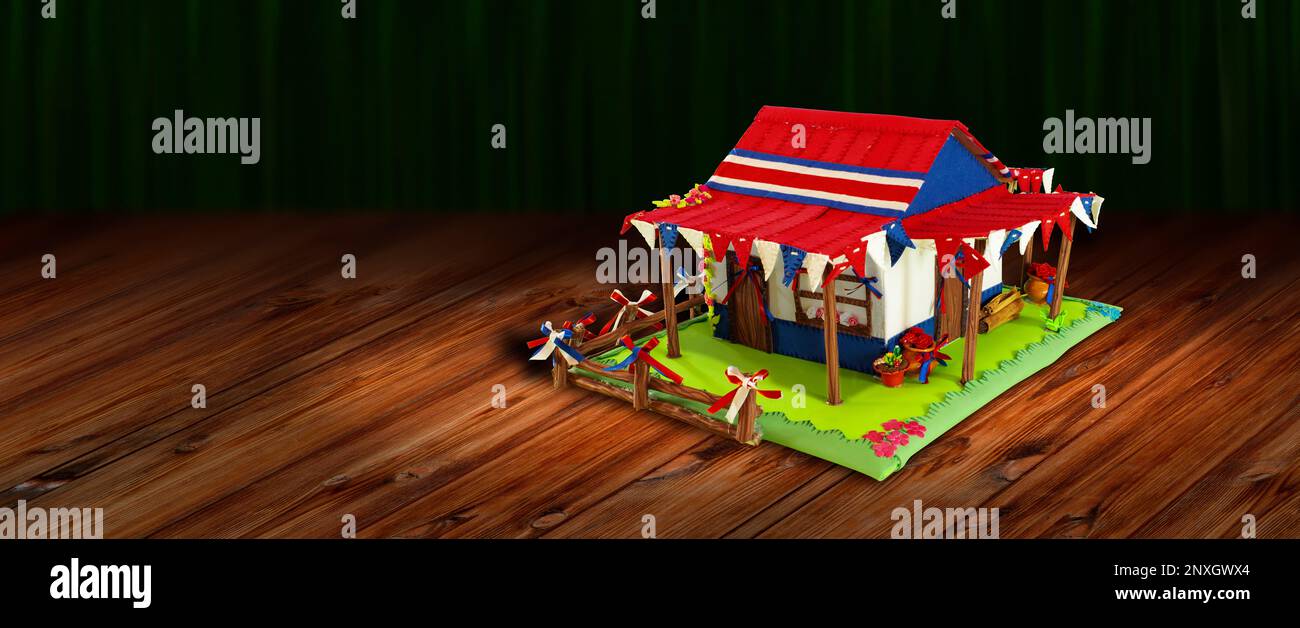 Typical Costa Rican country house surrounded with flowers and pennants made with foam decorated with blue, red and white flags and ribbons on a wooden Stock Photo