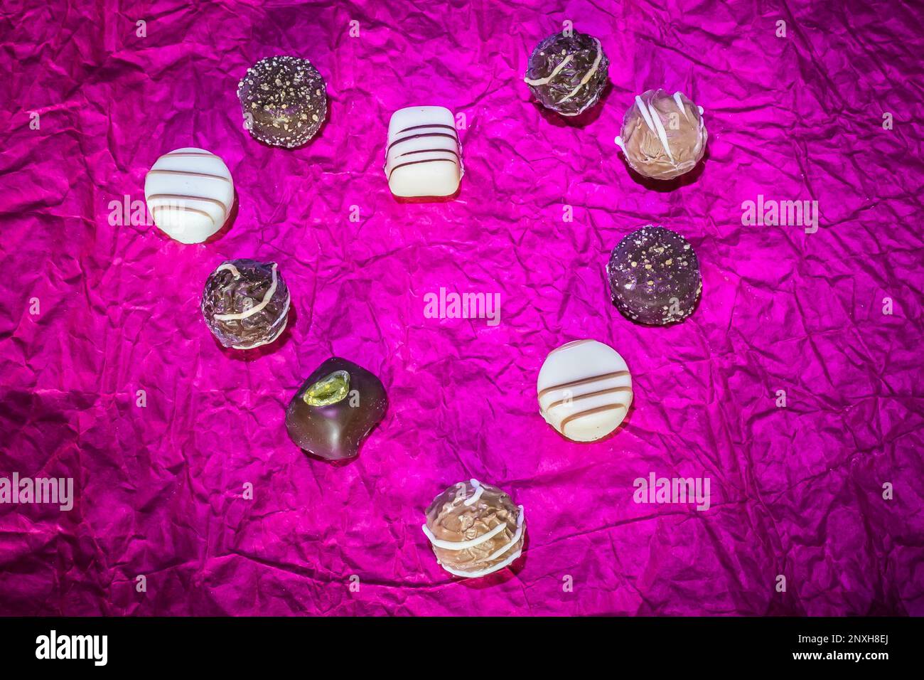 Variety of chocolate candy truffles pralines isolated on a shiny purple