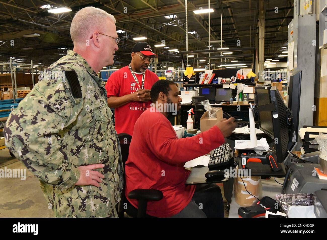 Jeremy Roberts, distribution process worker, Defense Logistics Agency Distribution Warner Robins, demonstrates distribution process applications to Rear Adm. Grafton Chase Jr., commander, DLA Distribution during his visit to the warehouse facility at Robins Air Force Base, Robins Air Force Base, Georgia, Jan. 12, 2023. DLA Distribution receives, stores, issues, and distributes material critical to achieve warfighter readiness and lethality. Stock Photo