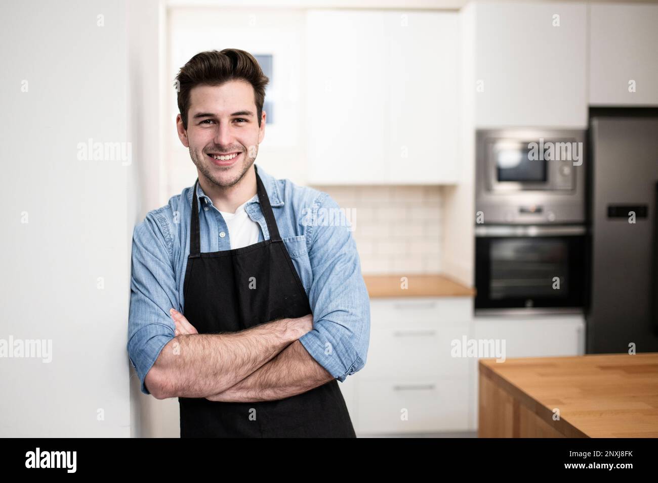 Man wearing apron cooking hi-res stock photography and images - Alamy