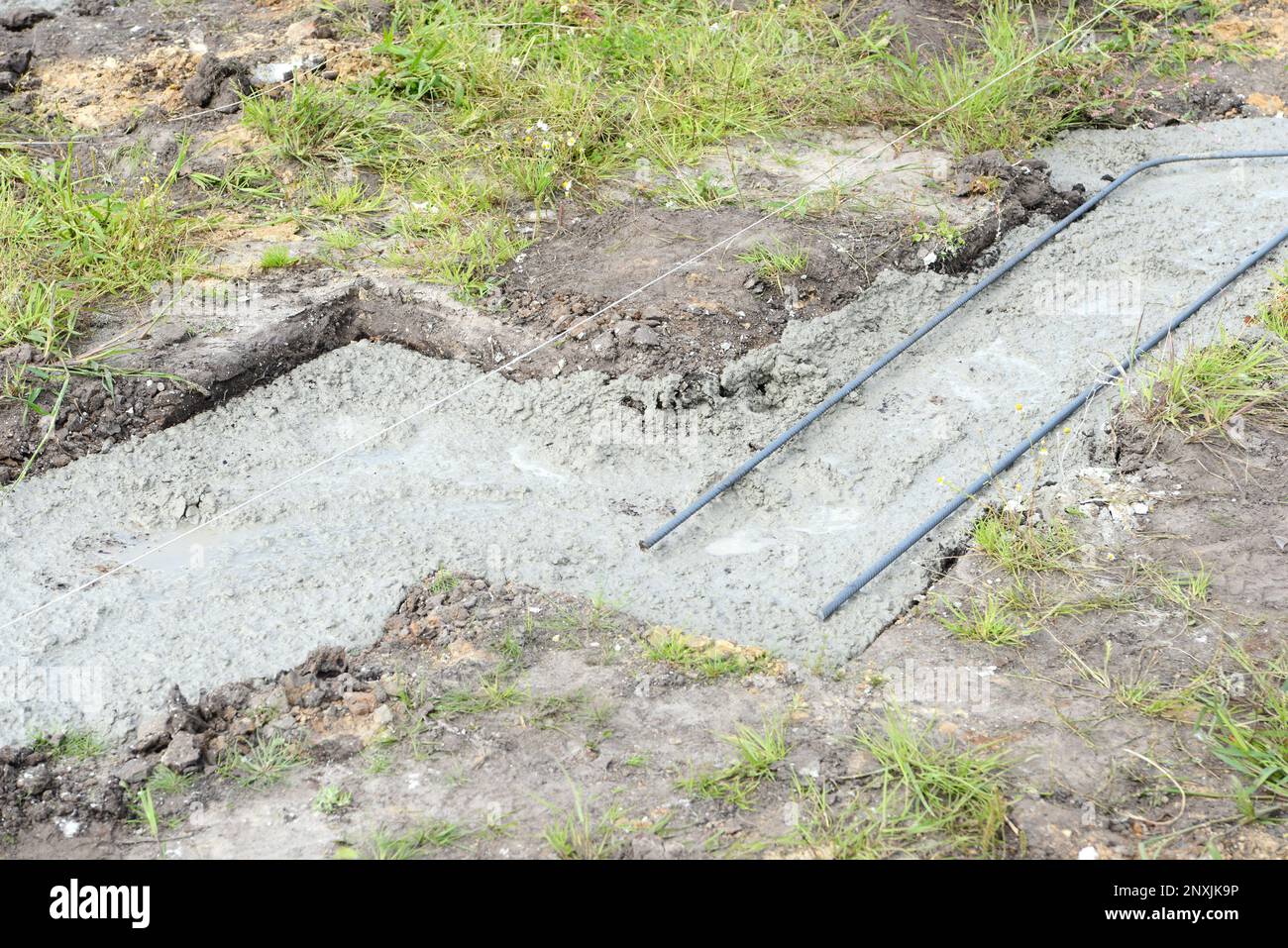 Filling strip foundation with concrete at the construction site. start of building a house. Stock Photo