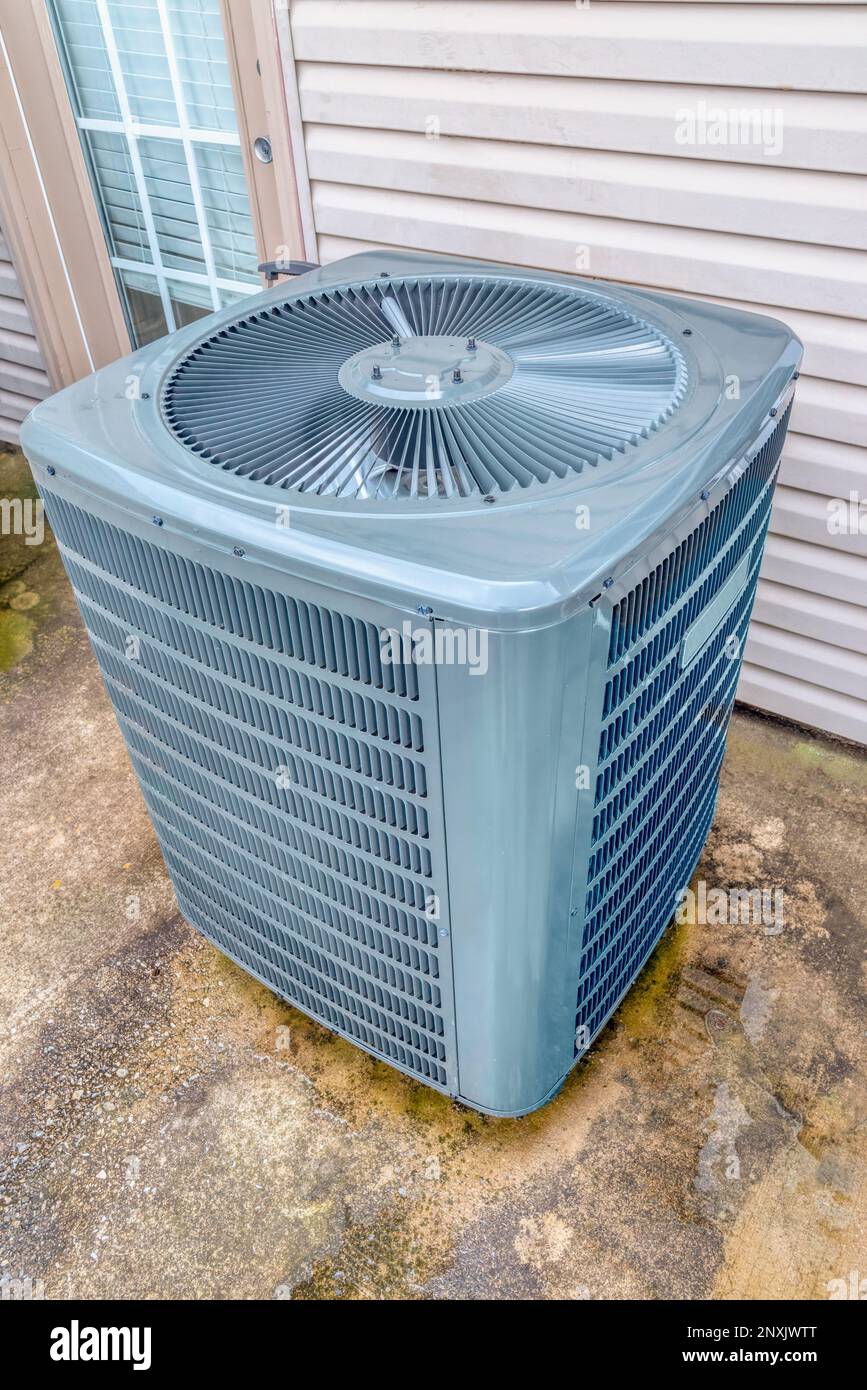 Vertical shot of a single air conditioning unit behind a rental condo unit. Stock Photo