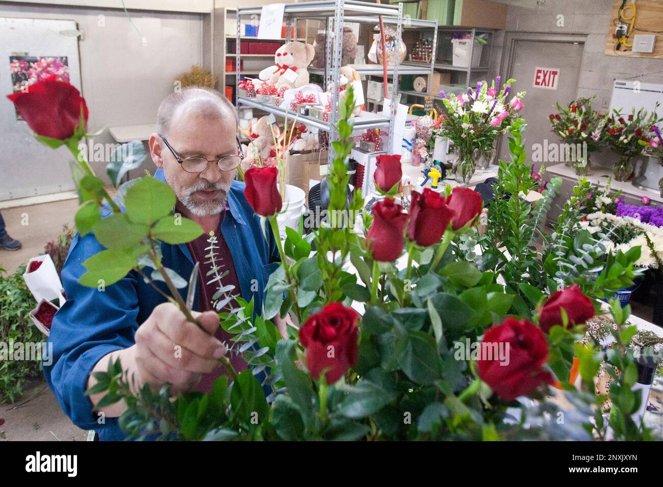 Kelly Fields arranges a bouquet of flowers in preparation for Valentine