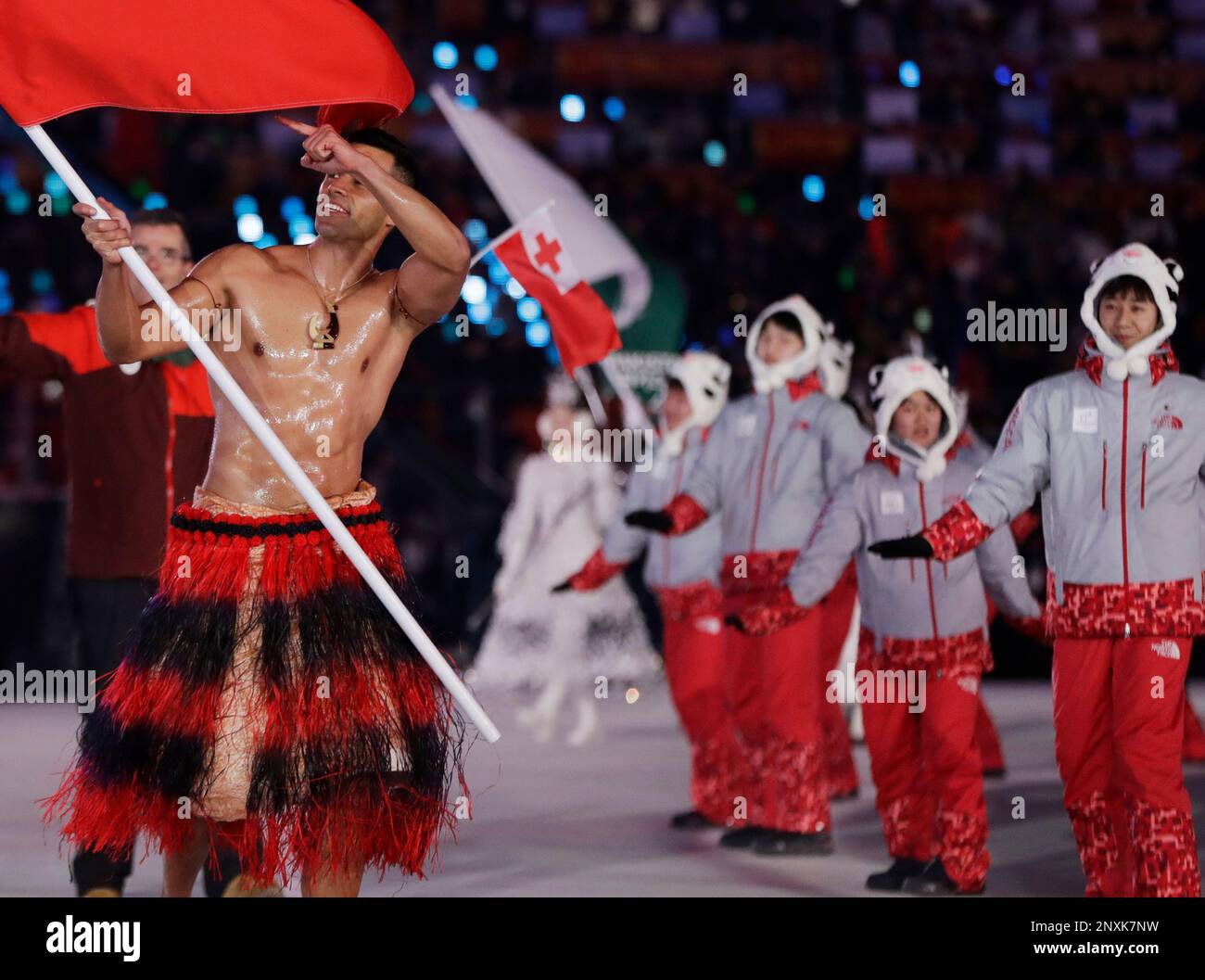 Pita Taufatofua carries the flag of Tonga during the opening ceremony