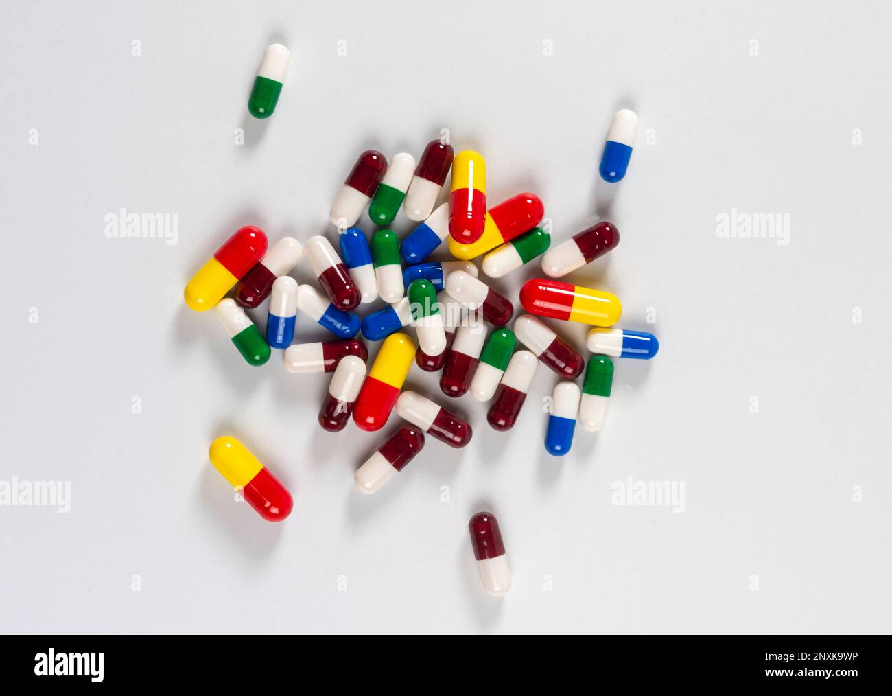 colored pills thrown on white background, top view Stock Photo
