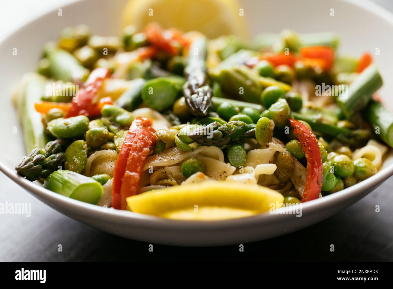 Pasta with fava beans, peas, asparagus and bell pepper Stock Photo Alamy