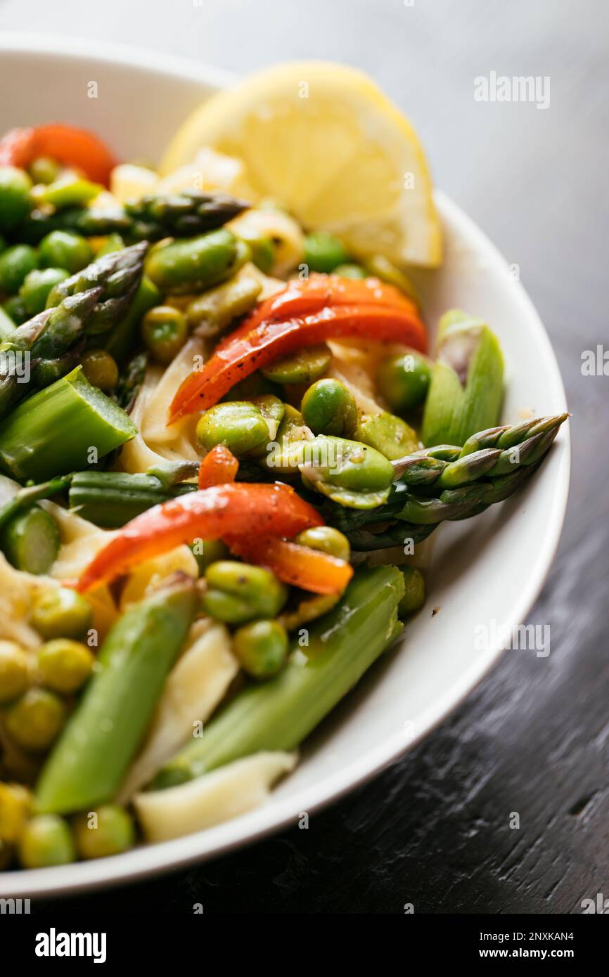 Pasta with fava beans, peas, asparagus and bell pepper Stock Photo Alamy