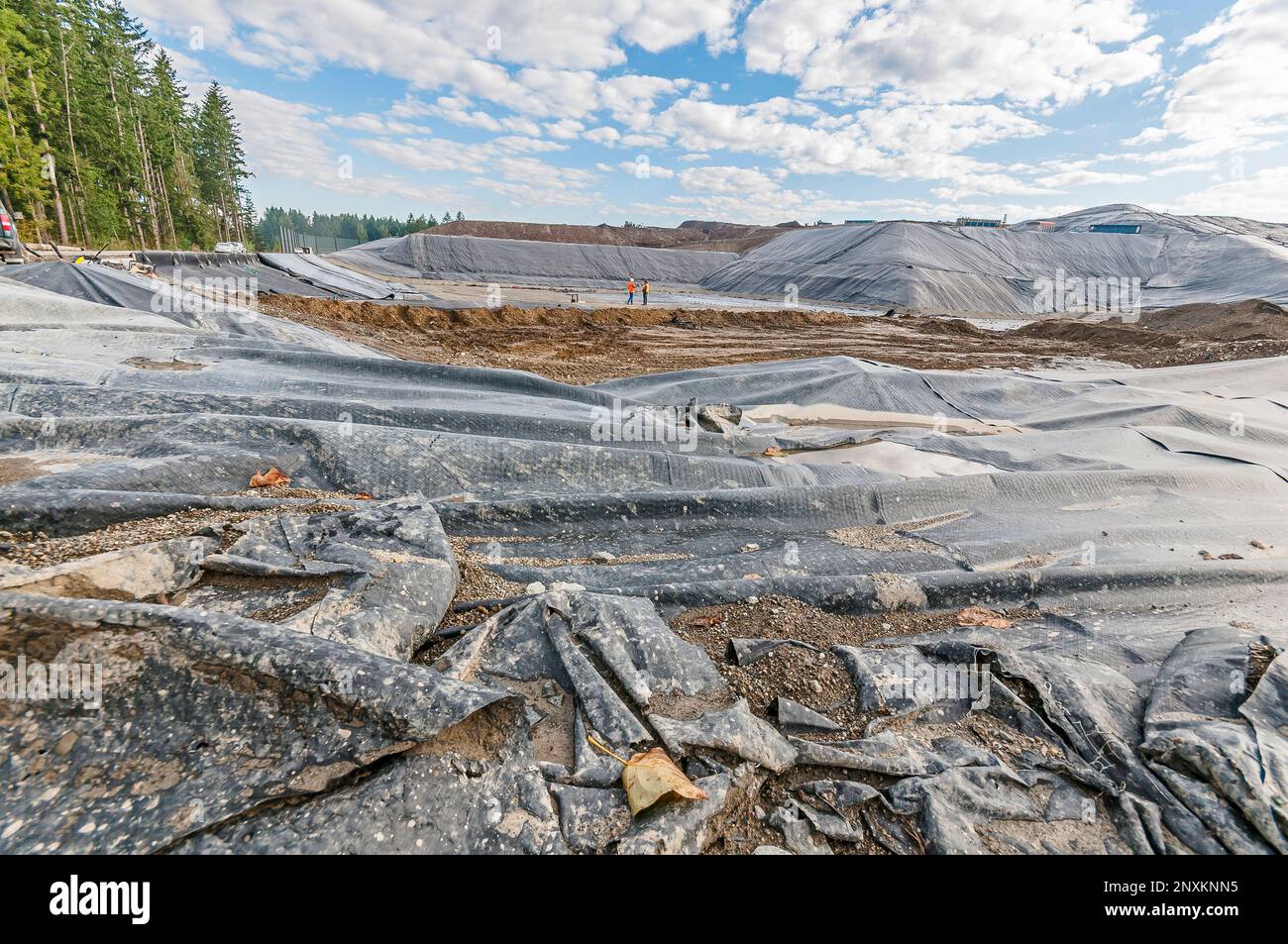 Vast areas of excavation and plastic geomembrane coverings at an active landfill. Stock Photo
