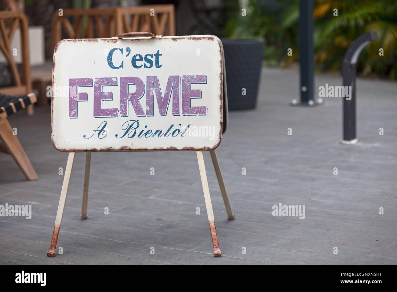 Metallic outdoor shop sign stating in french “C'est FERMÉ à Bientôt”, meaning in english “It's CLOSED see you soon”. Stock Photo