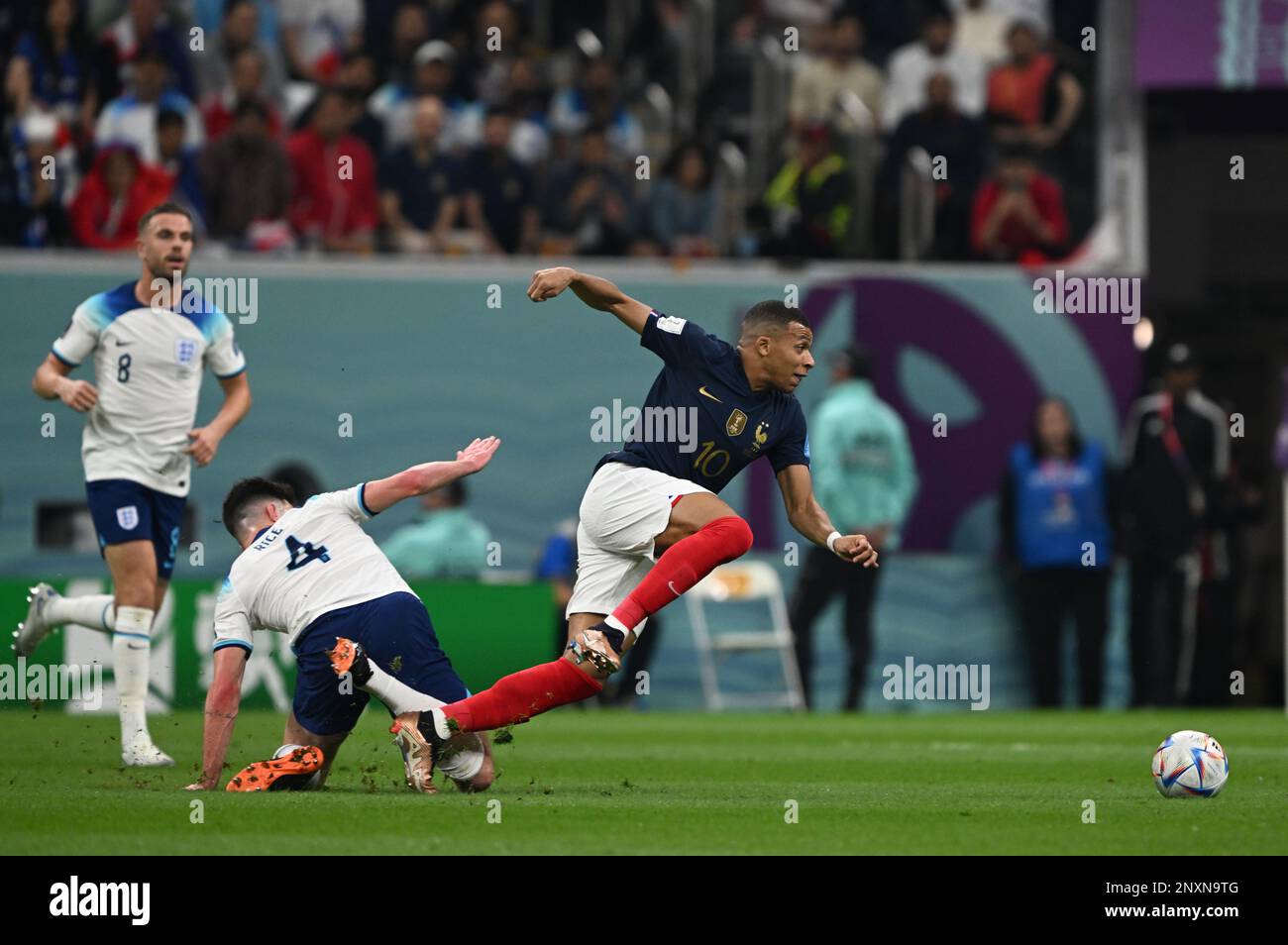 Kylian Mbappé (France) wins a footrace again England's Declan Rice during their quarter-final bout in Qatar as Jordan Henderson (ENG) looks on. Stock Photo