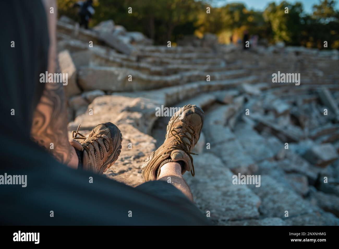 Man Sitting on Steps in Ancient Amphitheater Stock Photo