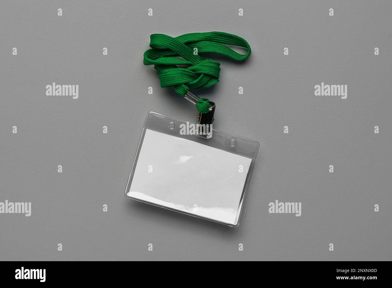 Blank badge with green lanyard on grey background Stock Photo - Alamy
