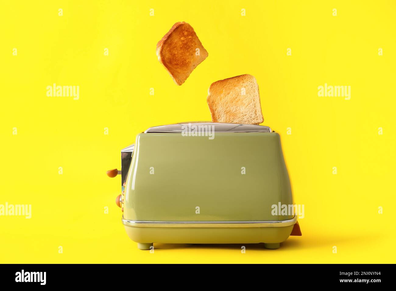 Modern toaster with crispy bread slices on yellow background Stock ...
